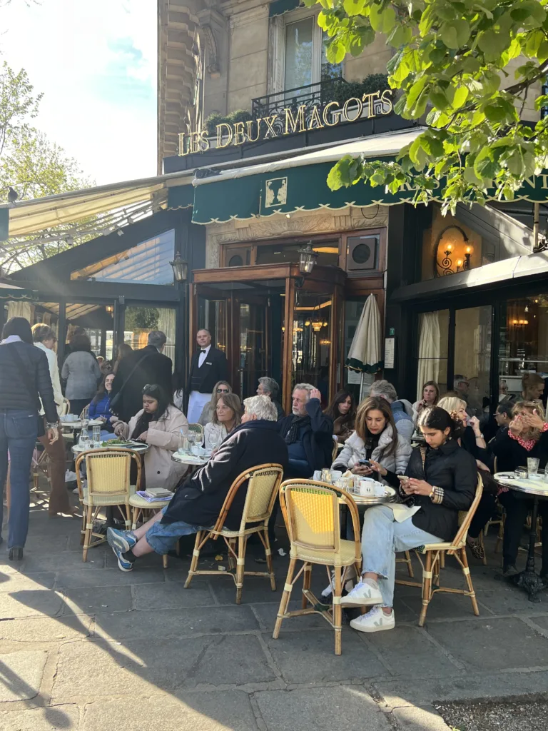 People sitting outside at Les Deux Magot in Paris.
