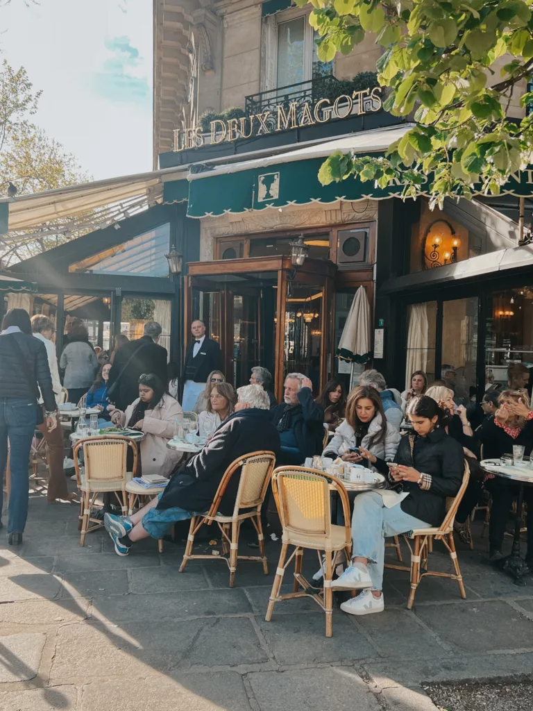 People sitting outside Les Deux Magot In Paris.