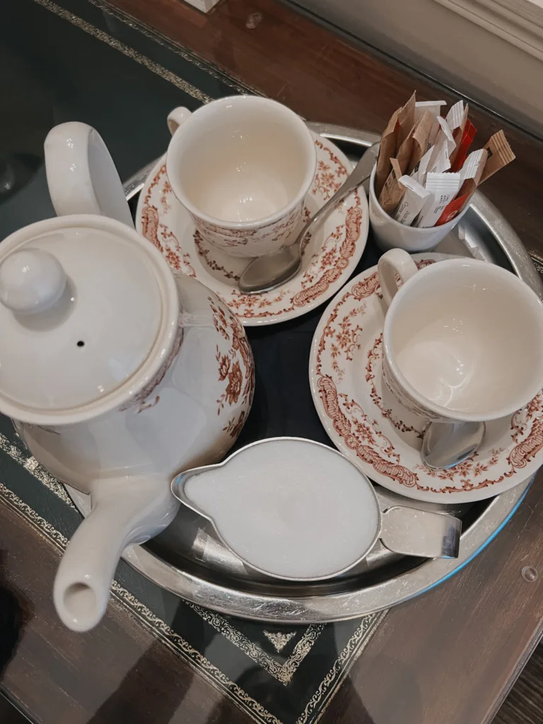 Empty coffee cups Empty coffee cups and white coffee pot sitting on a tray on a table.