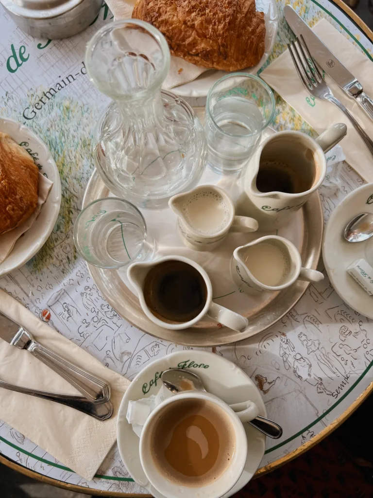 Table shot of coffee, cream, and croissant at Cafe de Flore in Paris.
