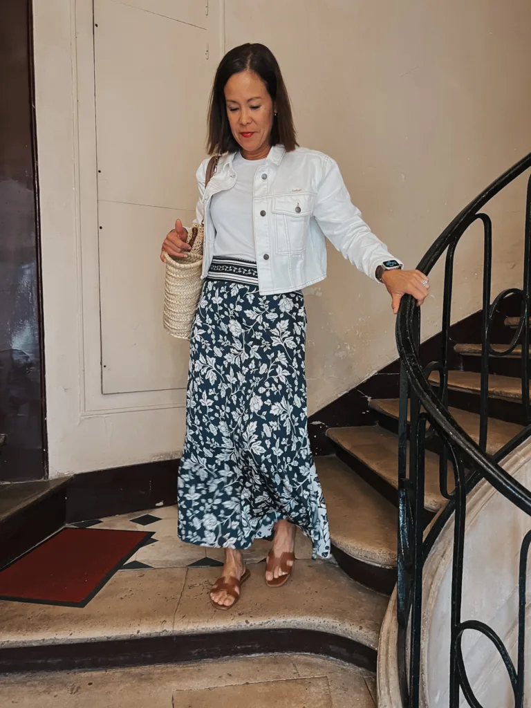 floral skirt and sandals Woman walking down stairs with skirt and white tee and sandals | Best Walking Shoes For Paris