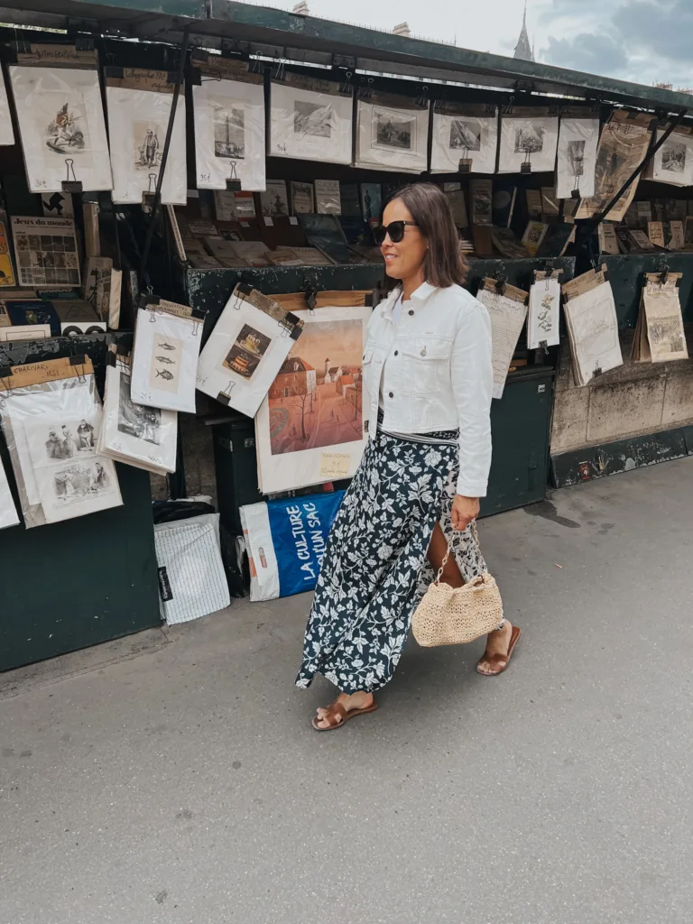 Seine bookstalls Woman walking along Seine bookstalls in white and navy skirt with white denim jacket.