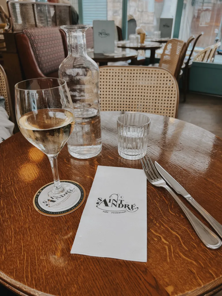 Menu of St. Andre cafe and wine glass sitting on table.