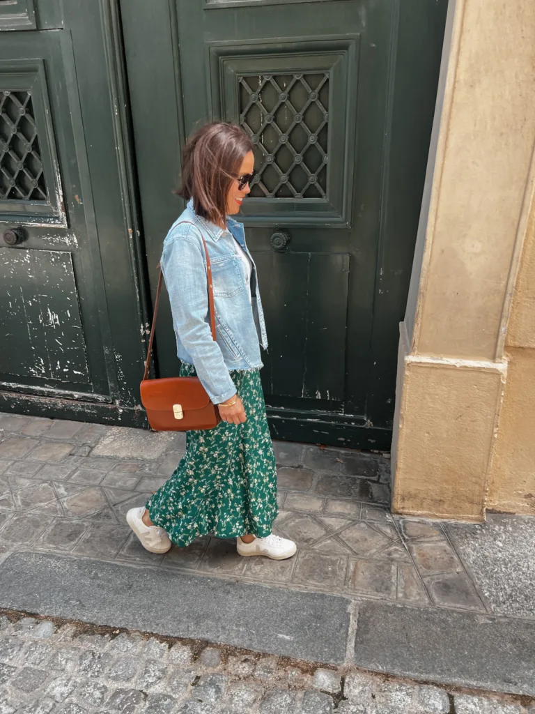 jean jacket and skirt Woman wearing jean jacket while walking down sidewalk.