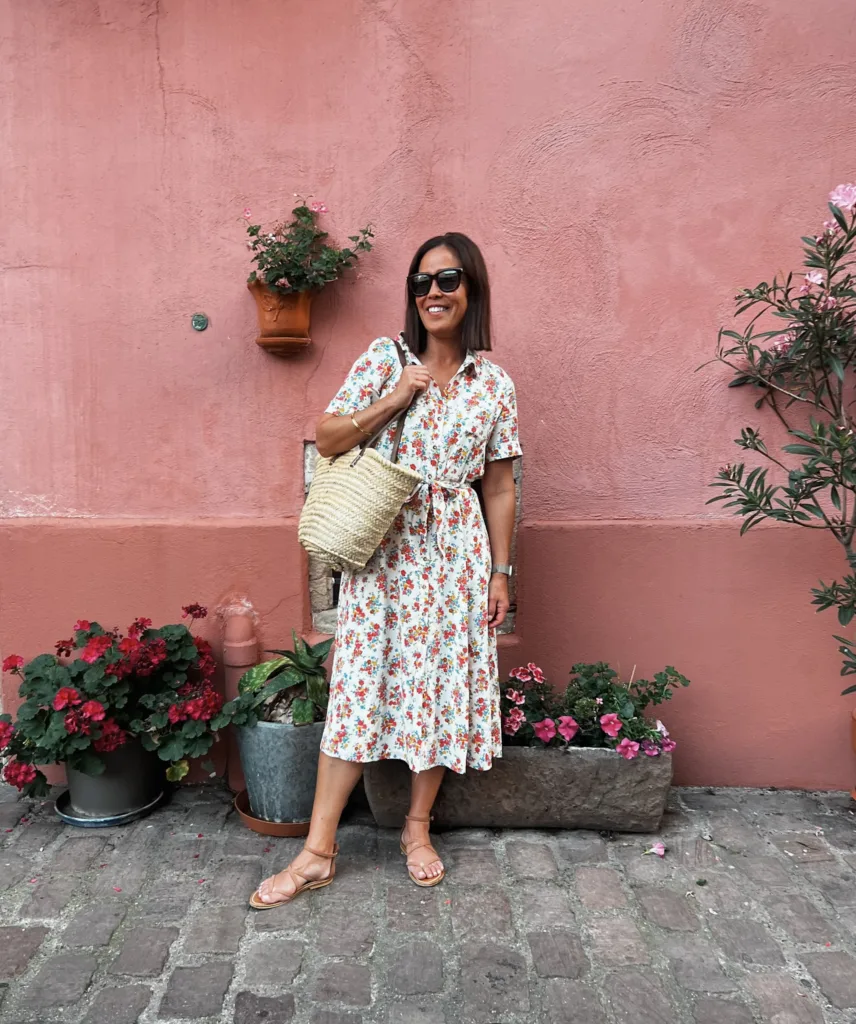 floral dress and sandals Woman in floral dress with sneakers and market tote.