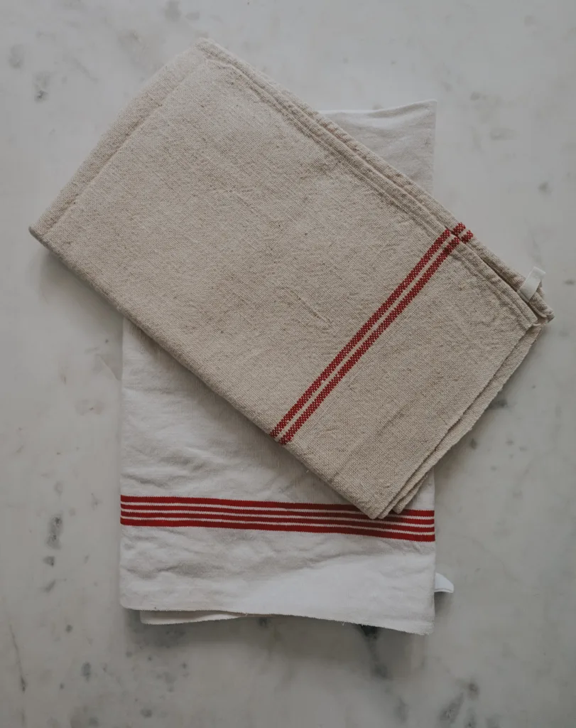 Red and white french linens sitting on marble table.