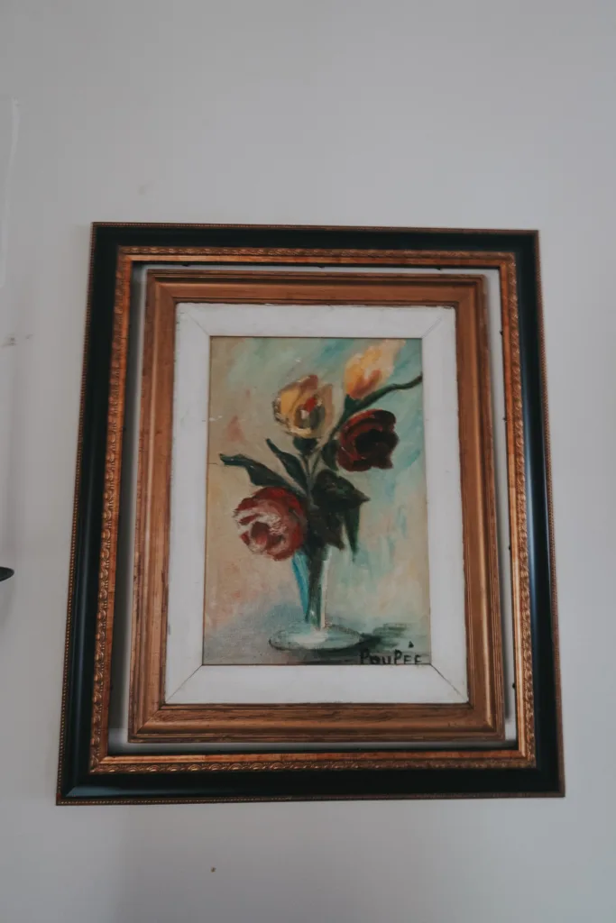 Flower artwork in a vase hanging on a wall.