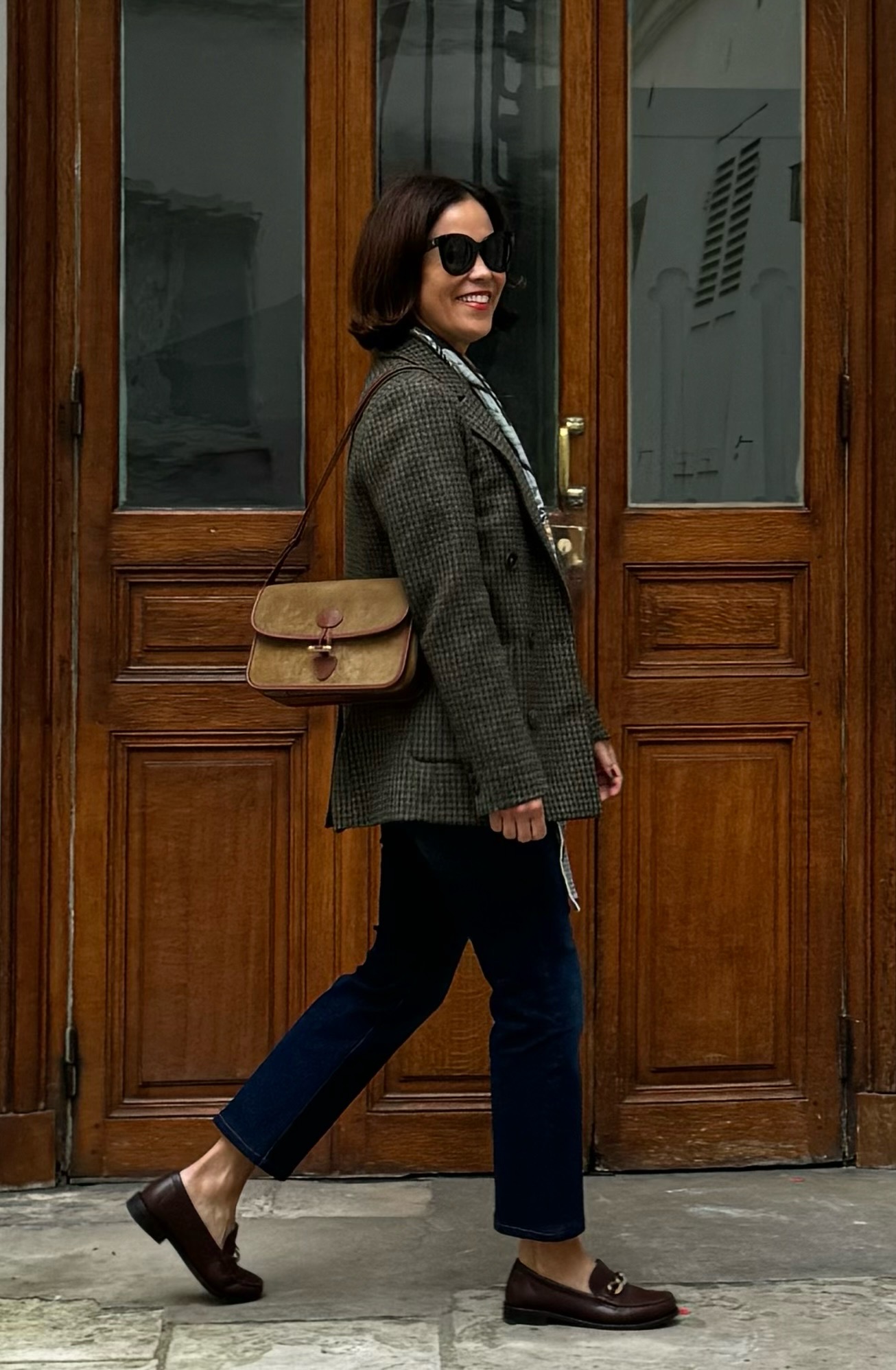 Woman wearing a blazer with denim and loafers in Paris.