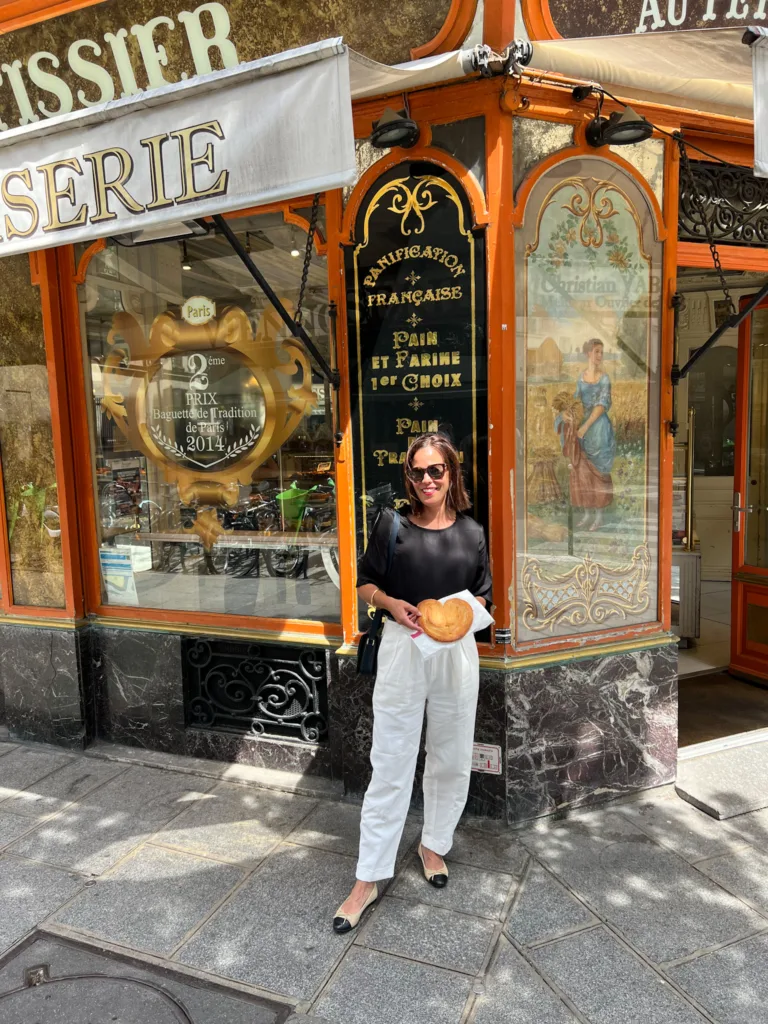 Woman standing holding a palmier wearing twill pants and a black top | Paris Outfits in July Part 2