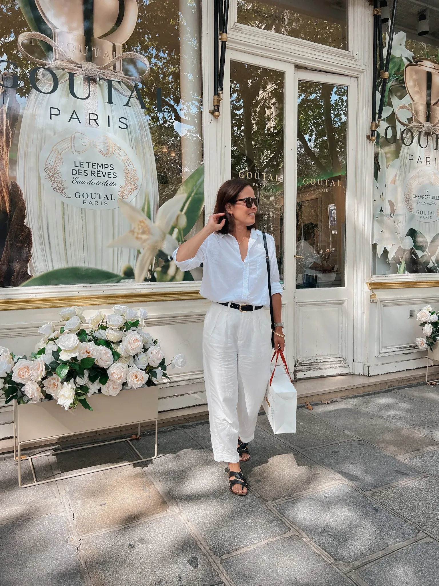 Woman wearing white top and twill pants in Paris.
