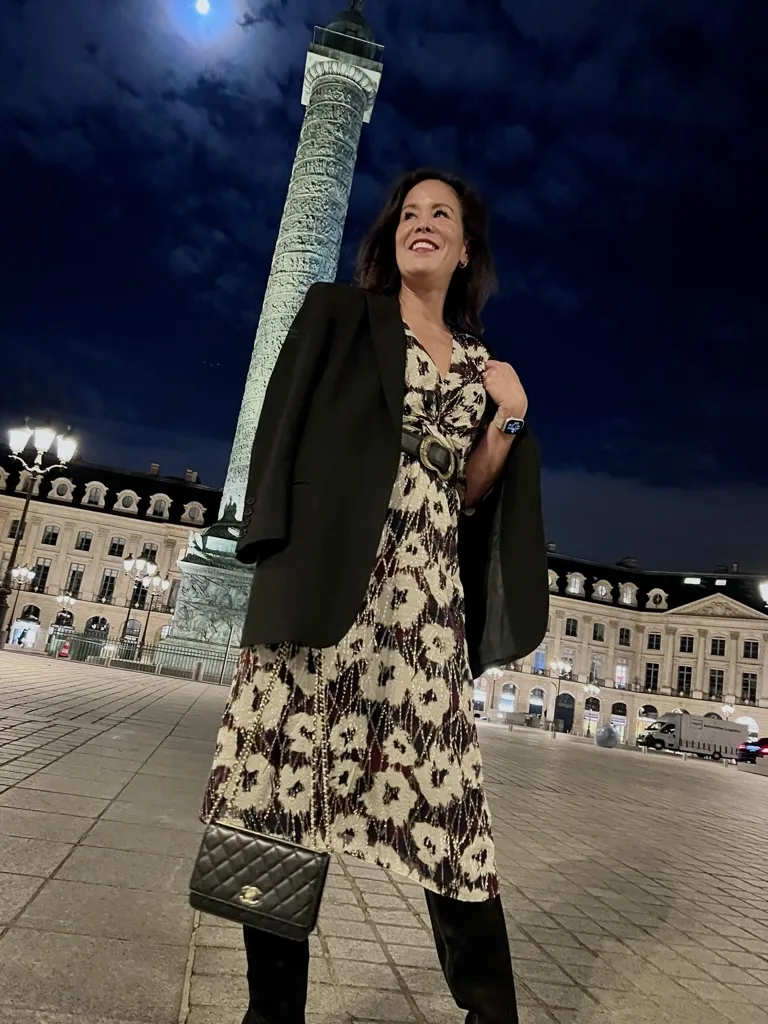 Woman wearing black boots and dress standing in Paris.