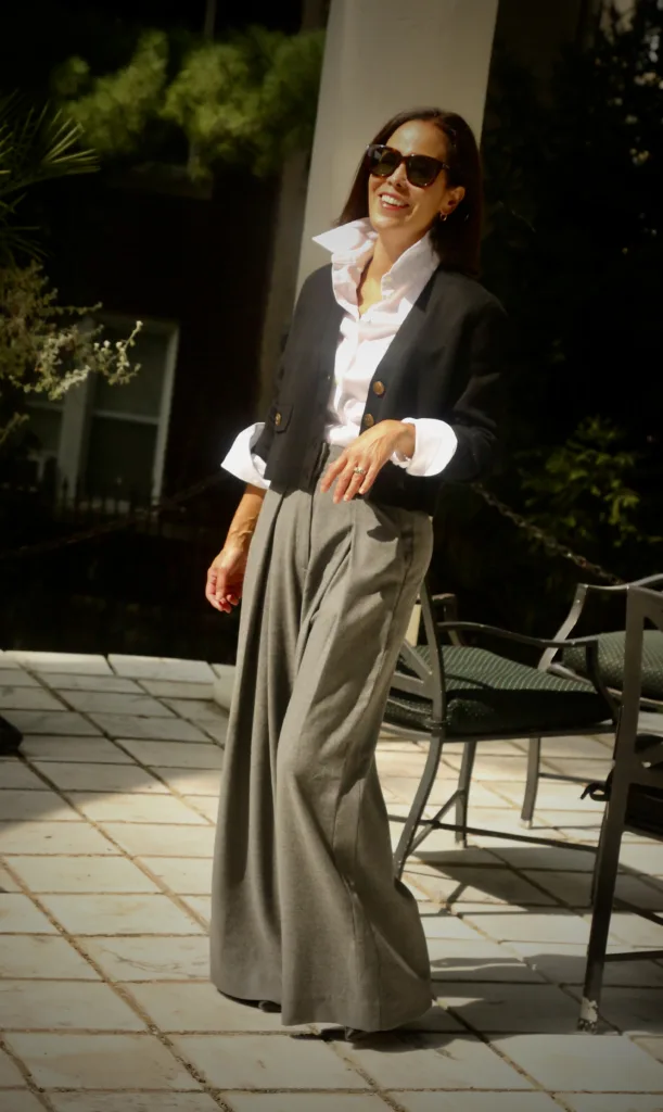 Woman wearing pants with black cardigan and white button down for elevated fall pieces at ME+EM.