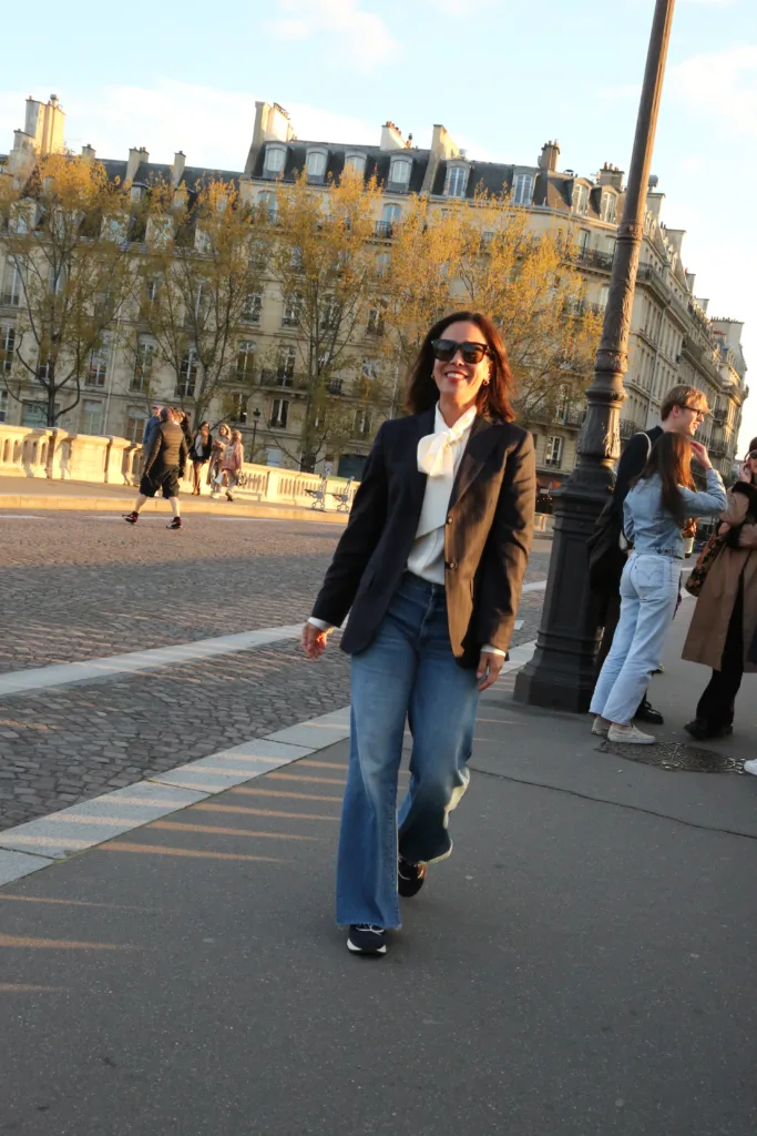 Woman wearing jeans with sneakers, blazer for what to wear in paris in fall.