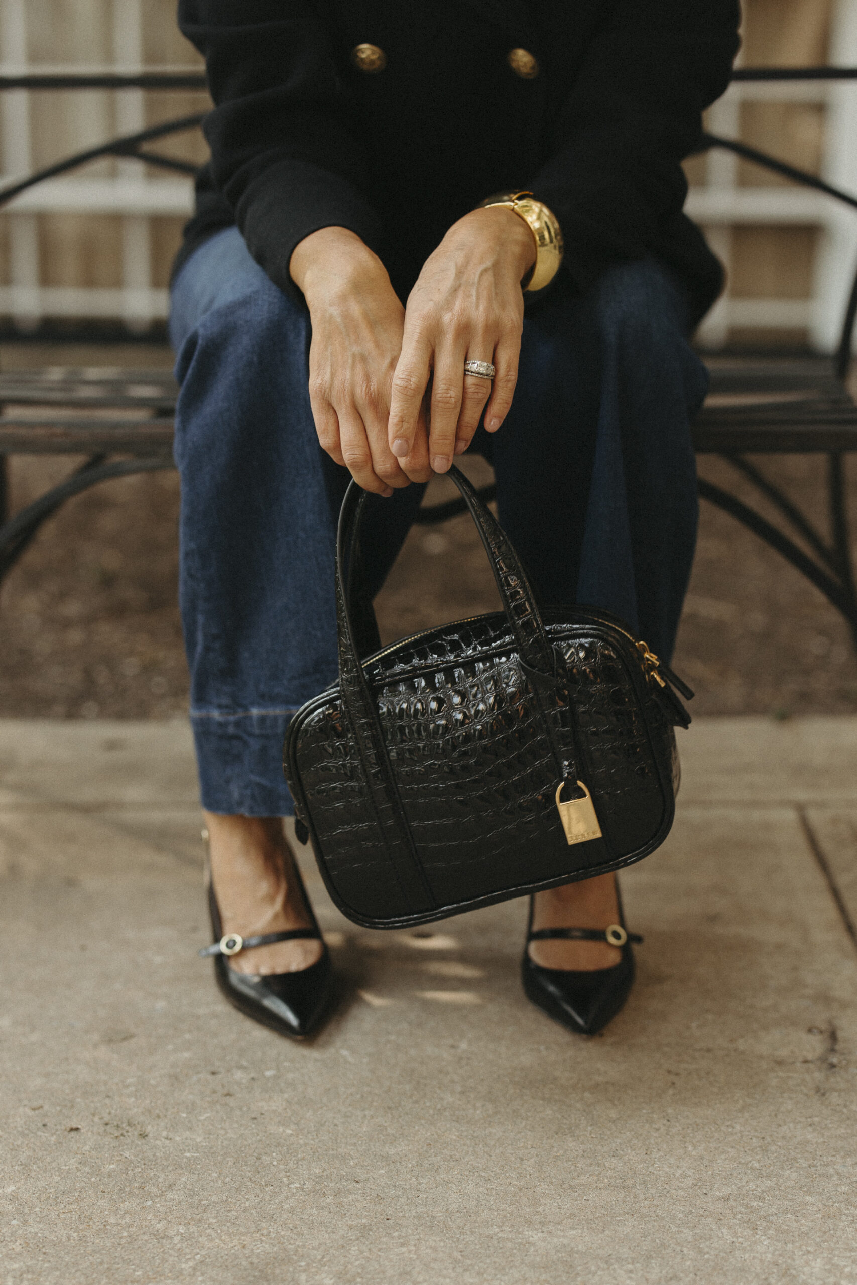 J.Crew black bag being held by woman .