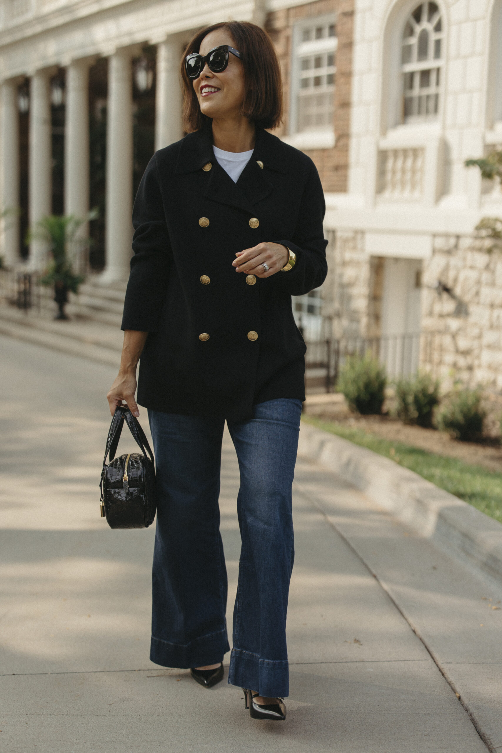 Woman wearing black sweater and denim.