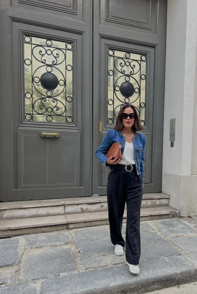 black pants denim jacket Woman with black pants, denim jacket, silk white cami and sneakers.