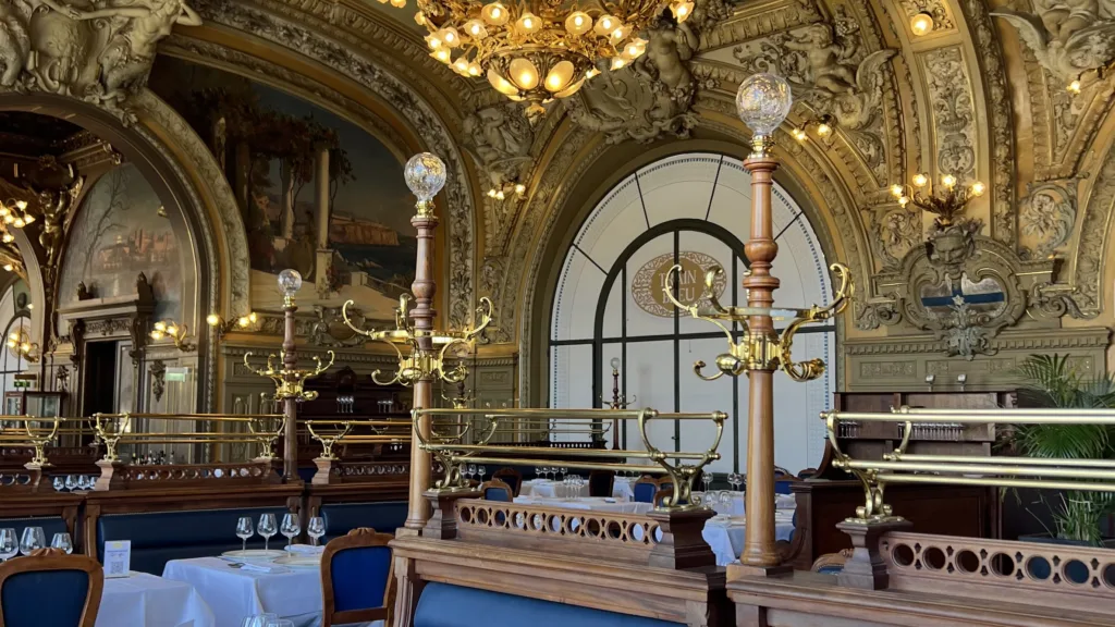 Le Train Bleu Picture of gold ceiling for french fridays and blue velvet chair.