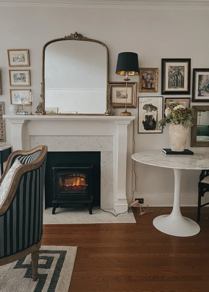 Interior of house with marble fireplace and mirror with french art on a wall.