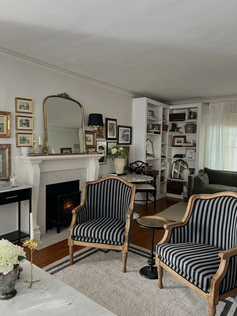 Striped chairs with gold mirror, rug, and green sofa.