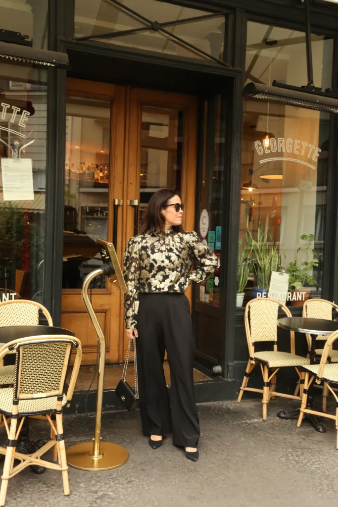 jacquard top and pants Woman standing wearing black pants and gold and black top.