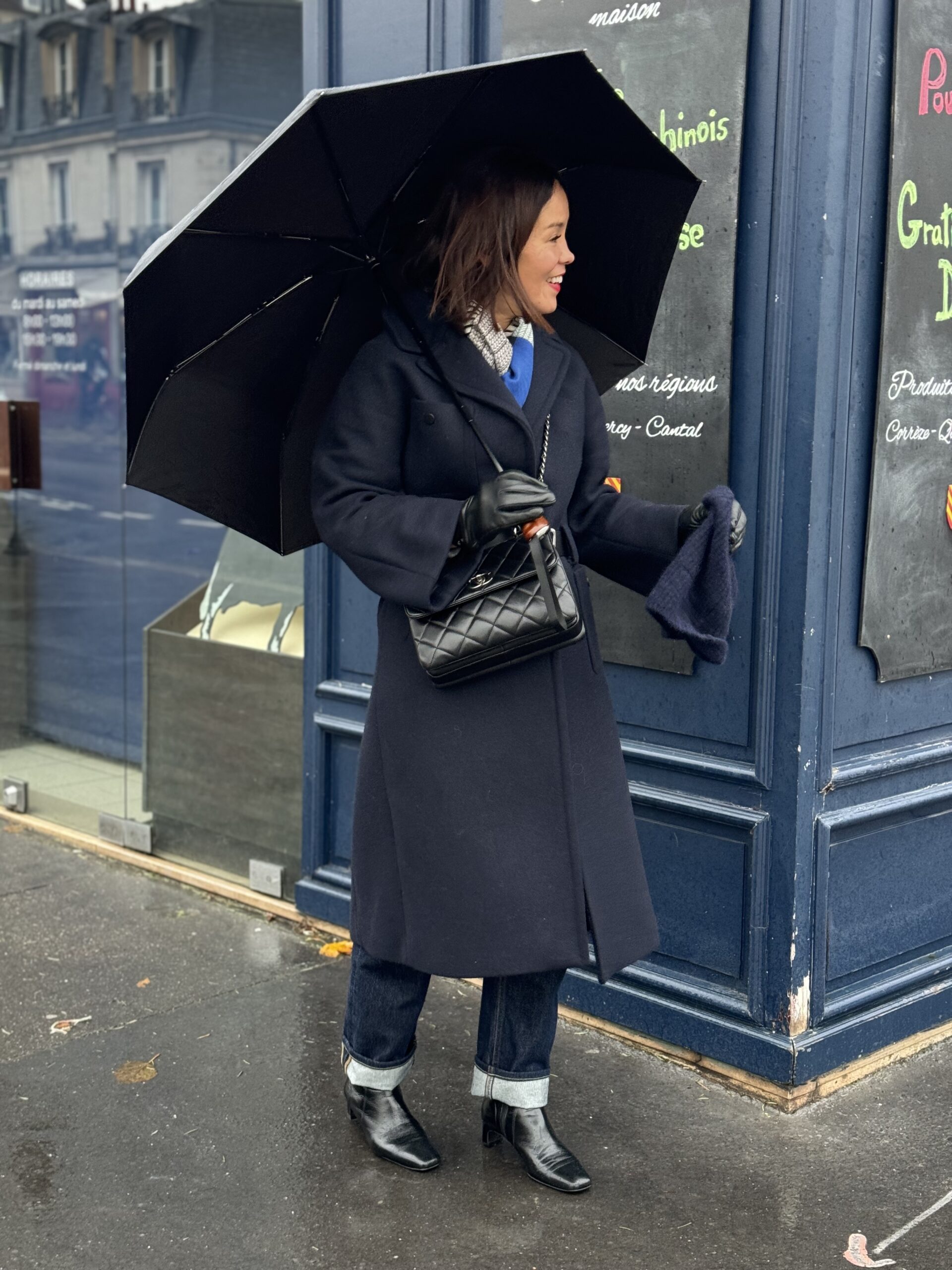 navy wool coat Woman with umbrella and navy wool coat standing in rain.