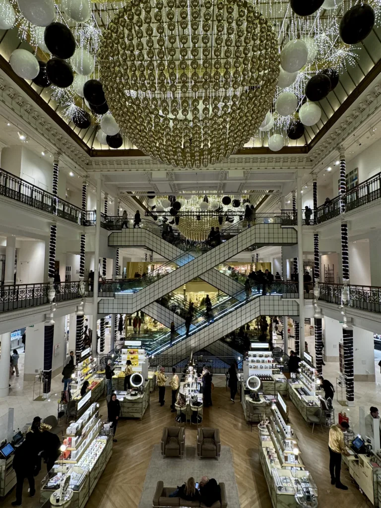 Escalators of people going up and down at le bon marche in paris.