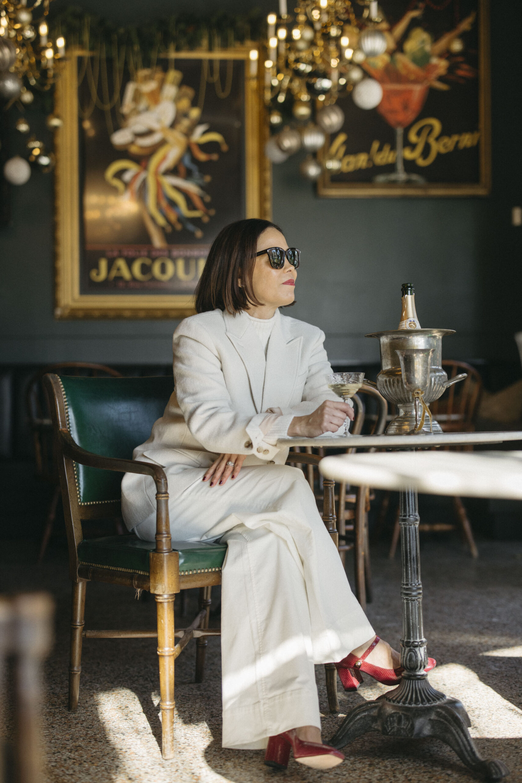 Woman sitting at a table ready to sip champagne.