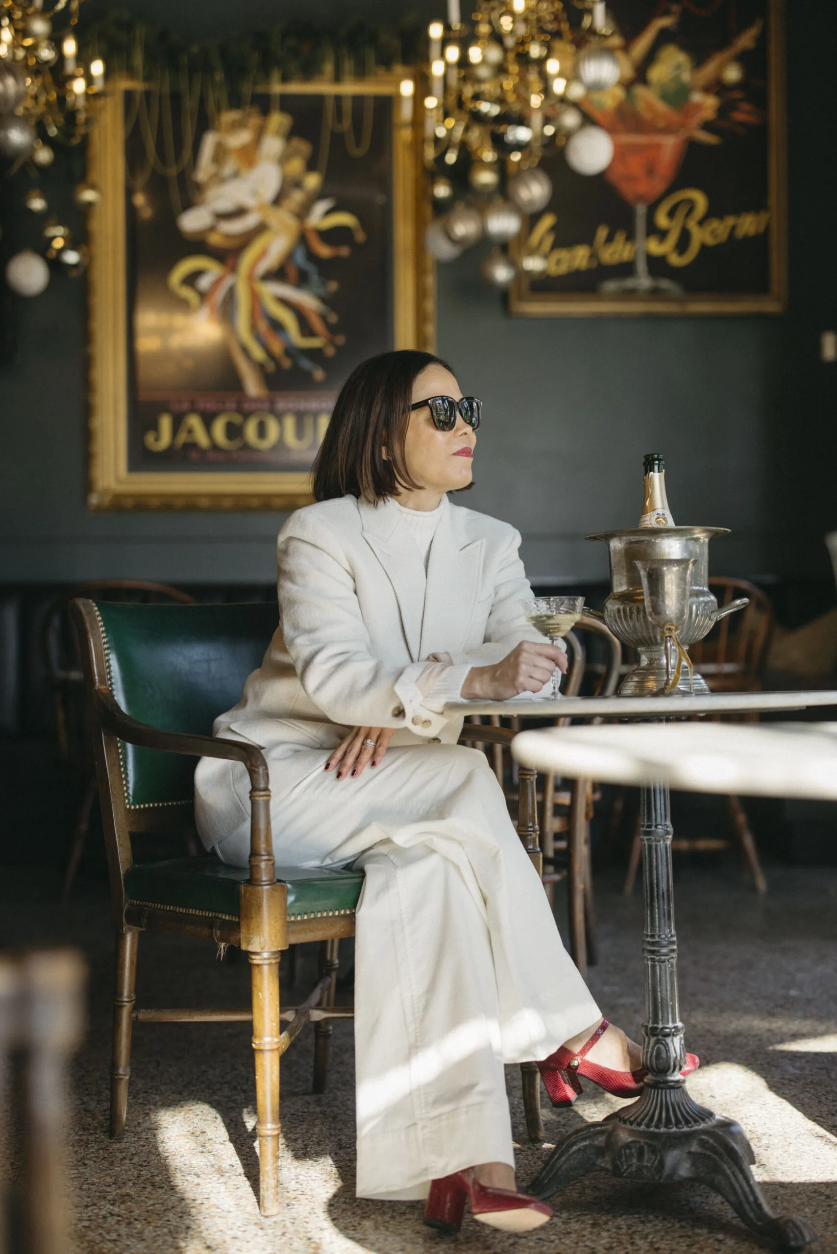 Woman sitting at a table ready to sip champagne.