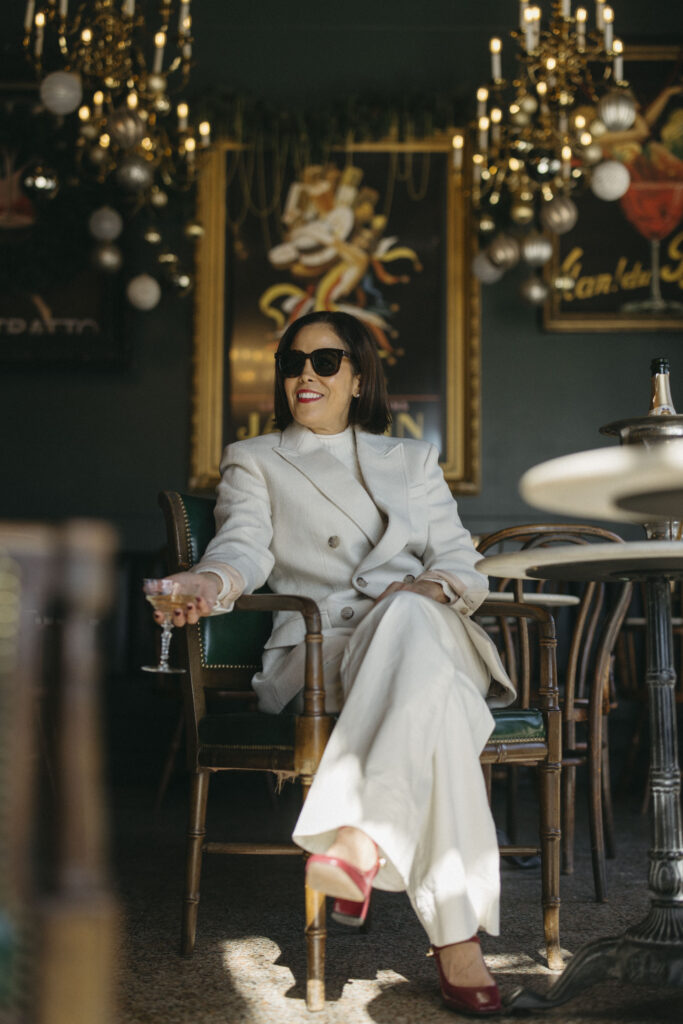 Woman in all white at a table in a french girl party look.