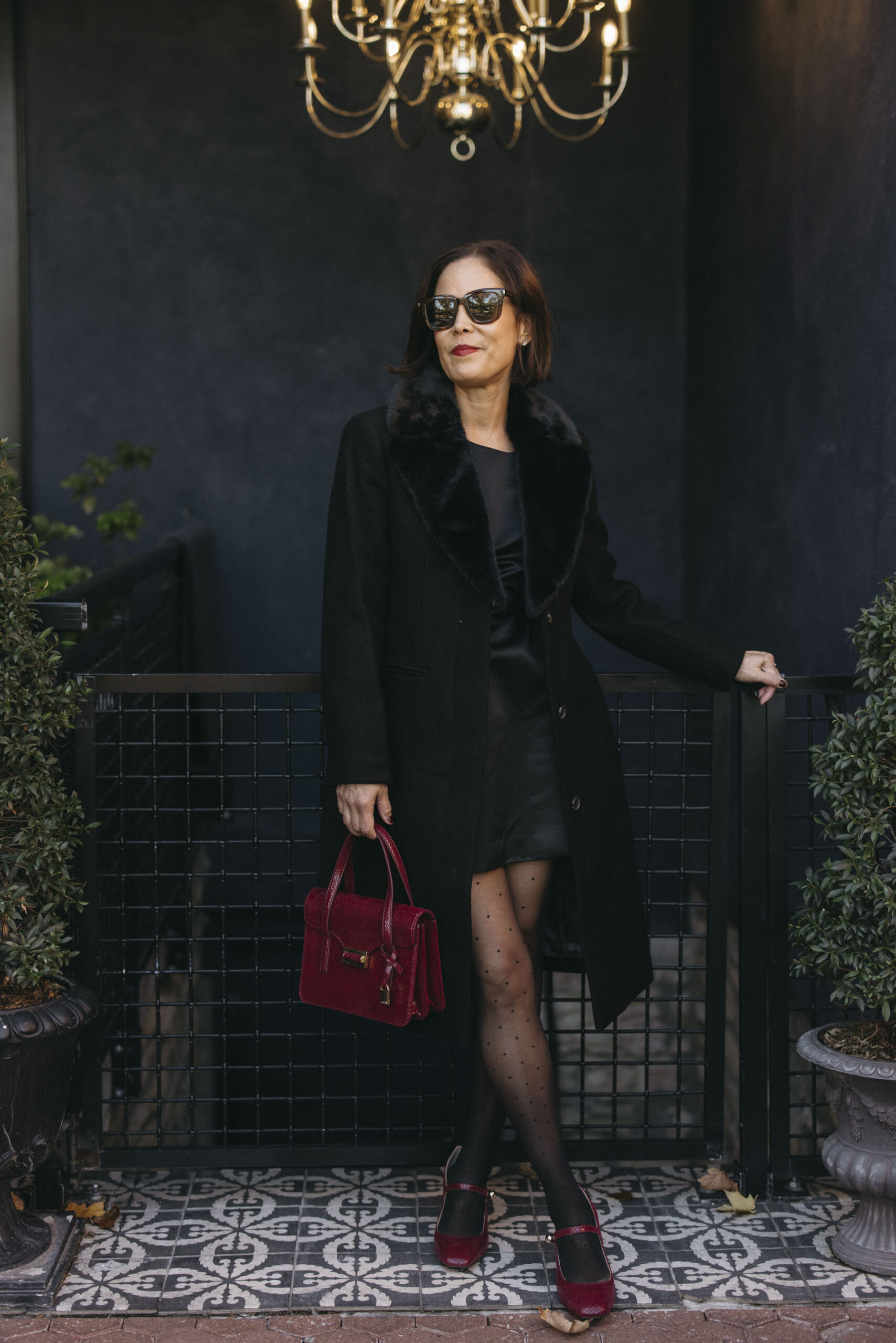 Woman wearing black dress with heels at a restaurant.