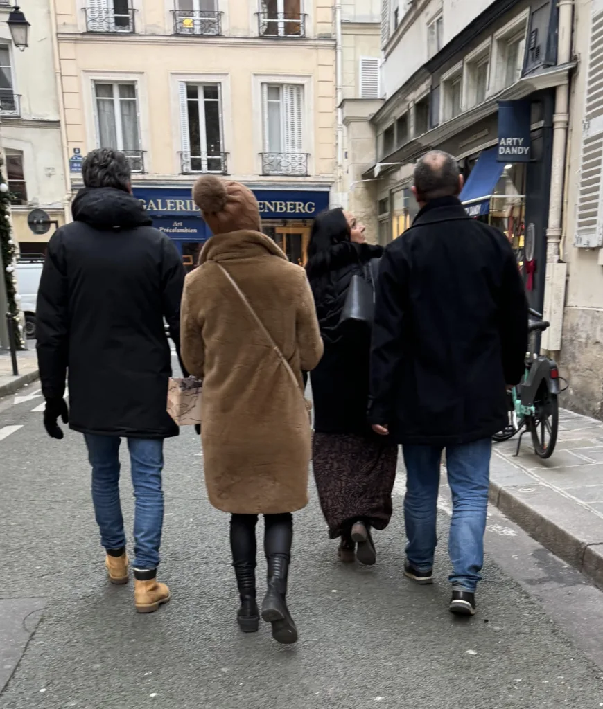 How to pack for Paris during the winter season. 4 people walking down street in paris looking chic and stylish.