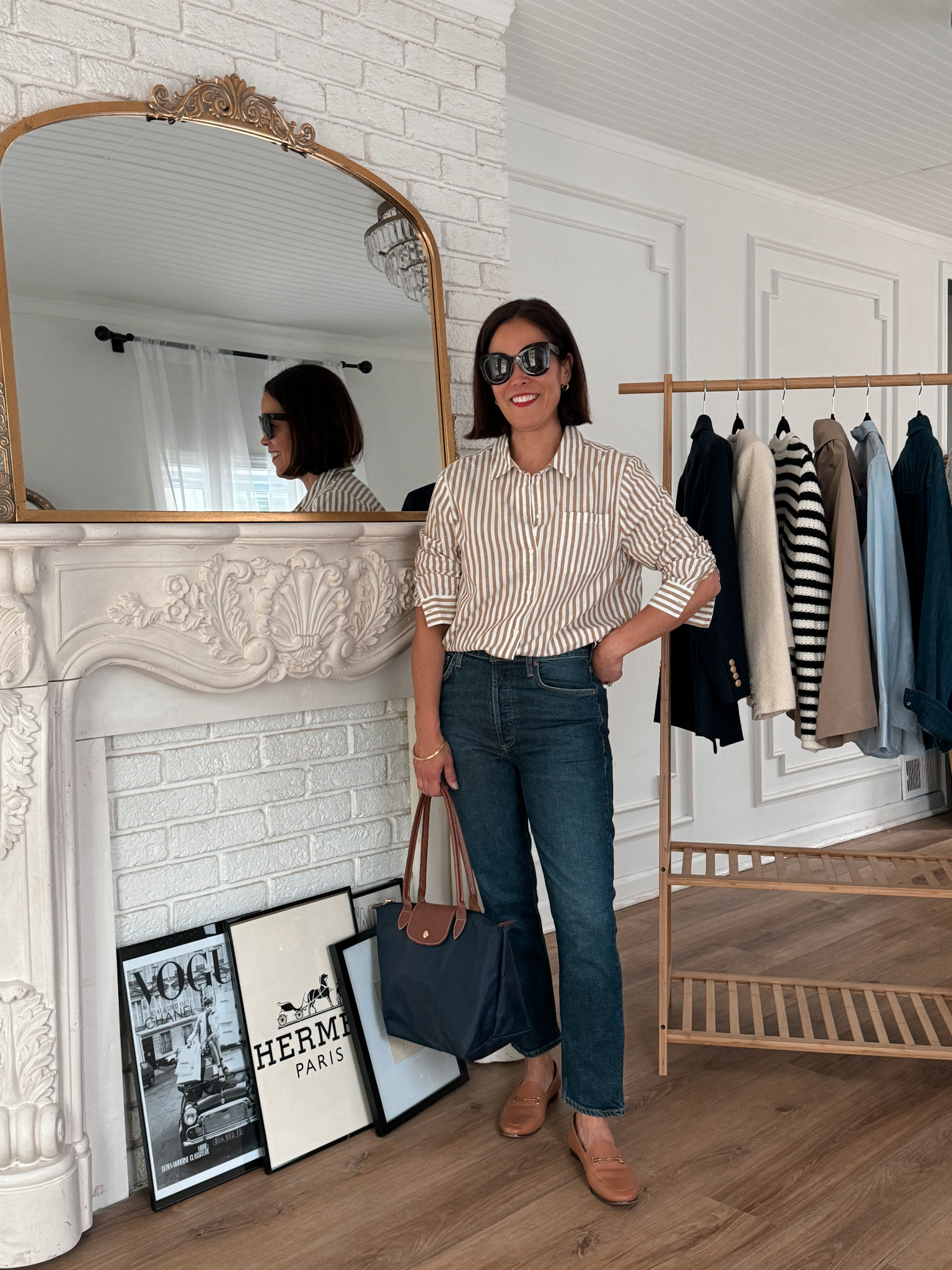 Woman wearing dark denim jeans with stripe button down showing jeans to wear in Paris.