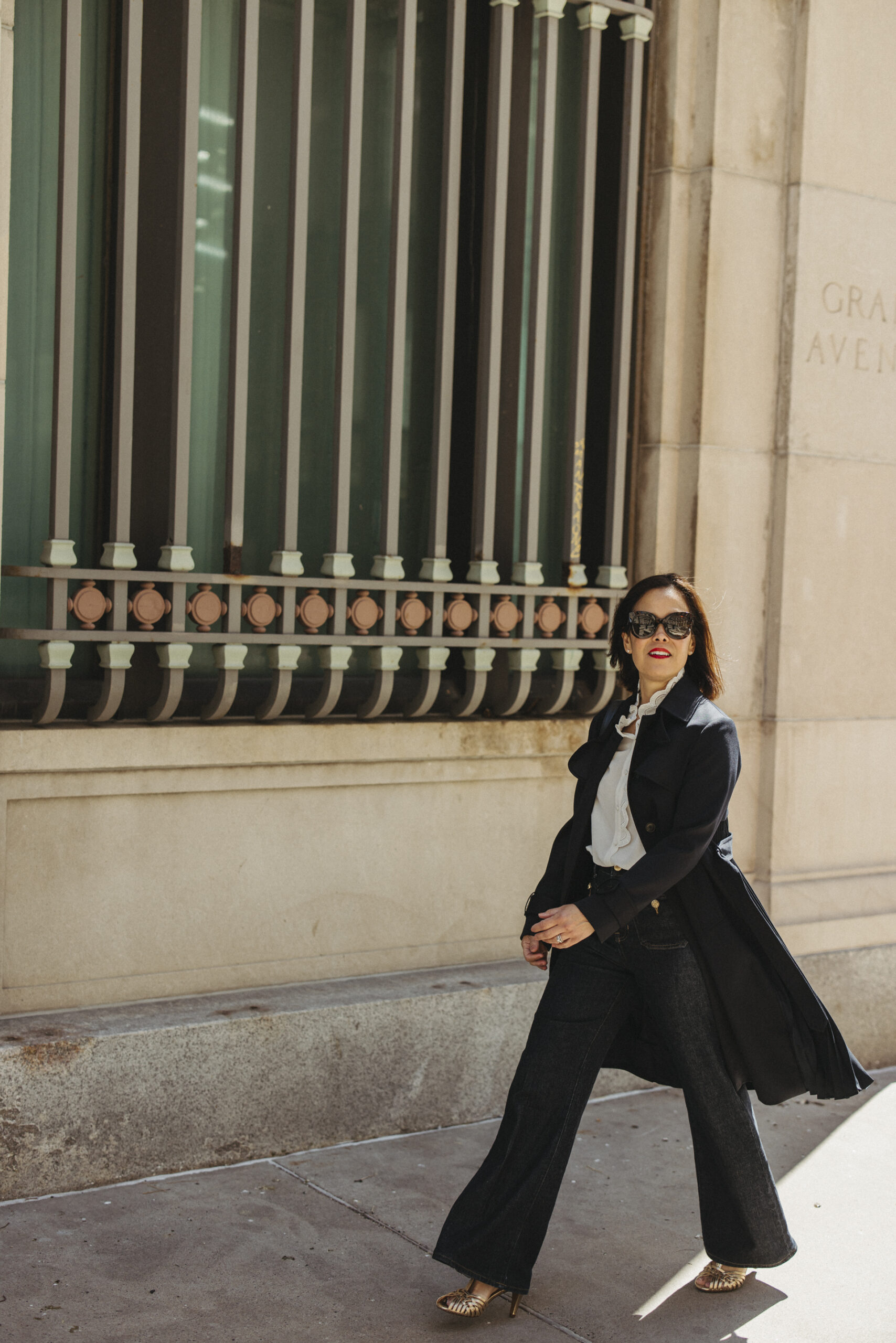 Woman wearing dark denim and a navy trench coat for jeans to wear in Paris.