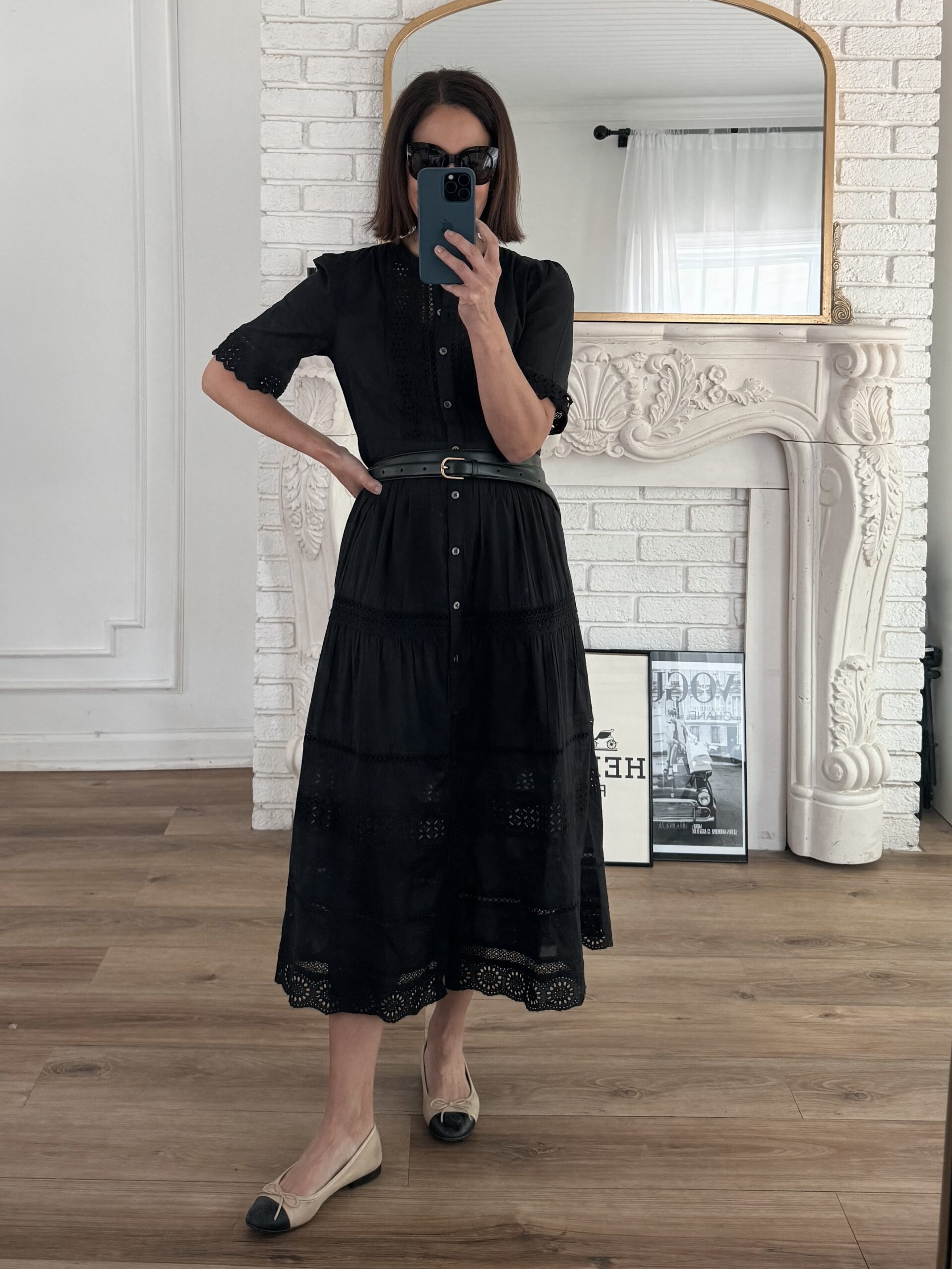 Woman wearing black dress with ballet flats and belt.