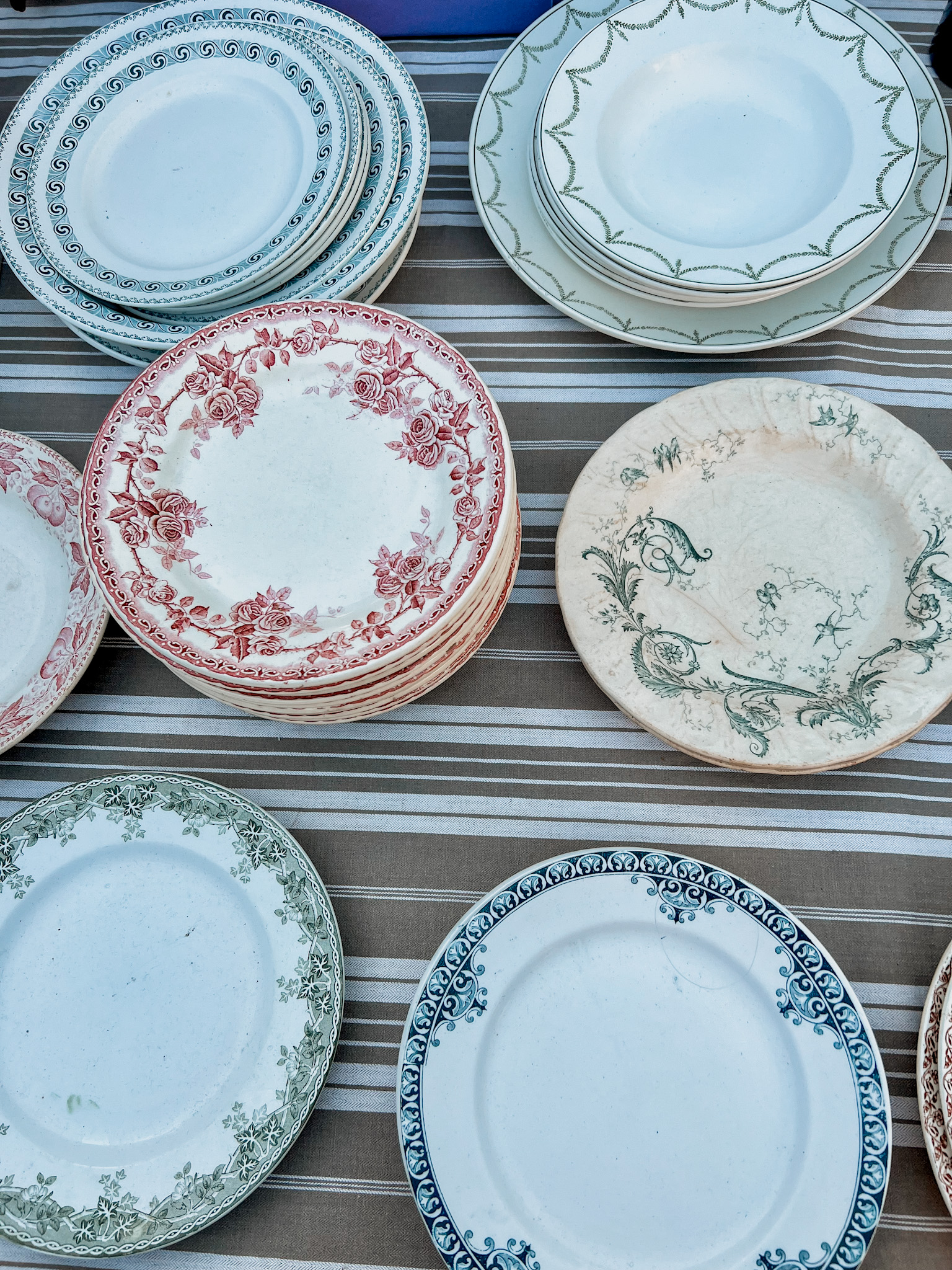 French dinnerware sitting on a table at a flea market in paris.