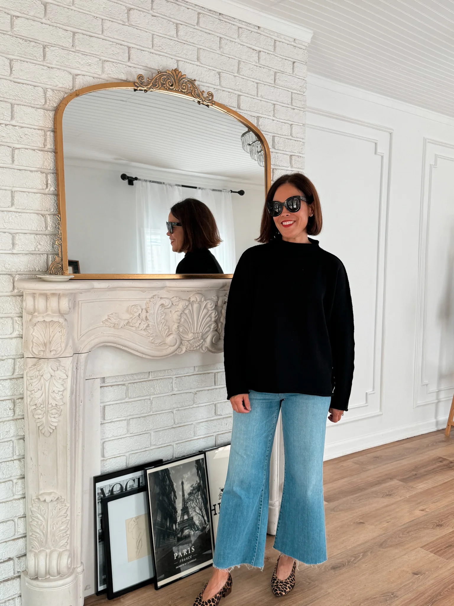 Woman wearing jeans with black sweater and flats.