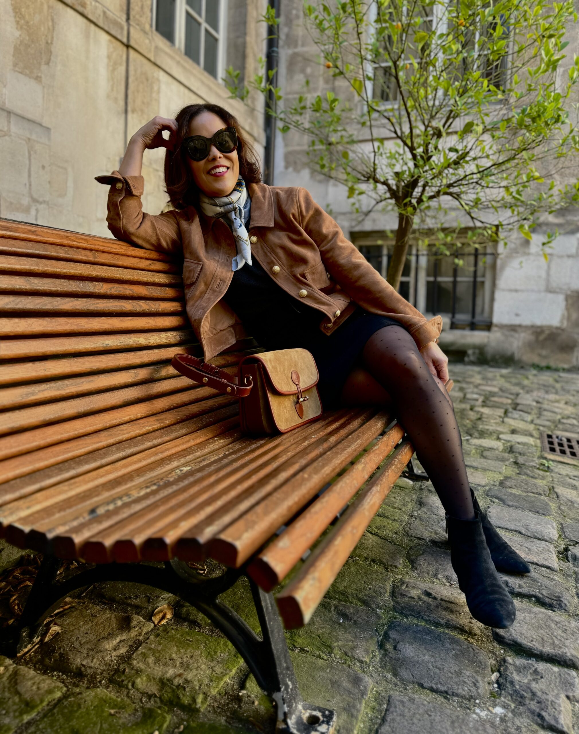 Woman wearing scarf with 10 pieces I always pack for Paris.