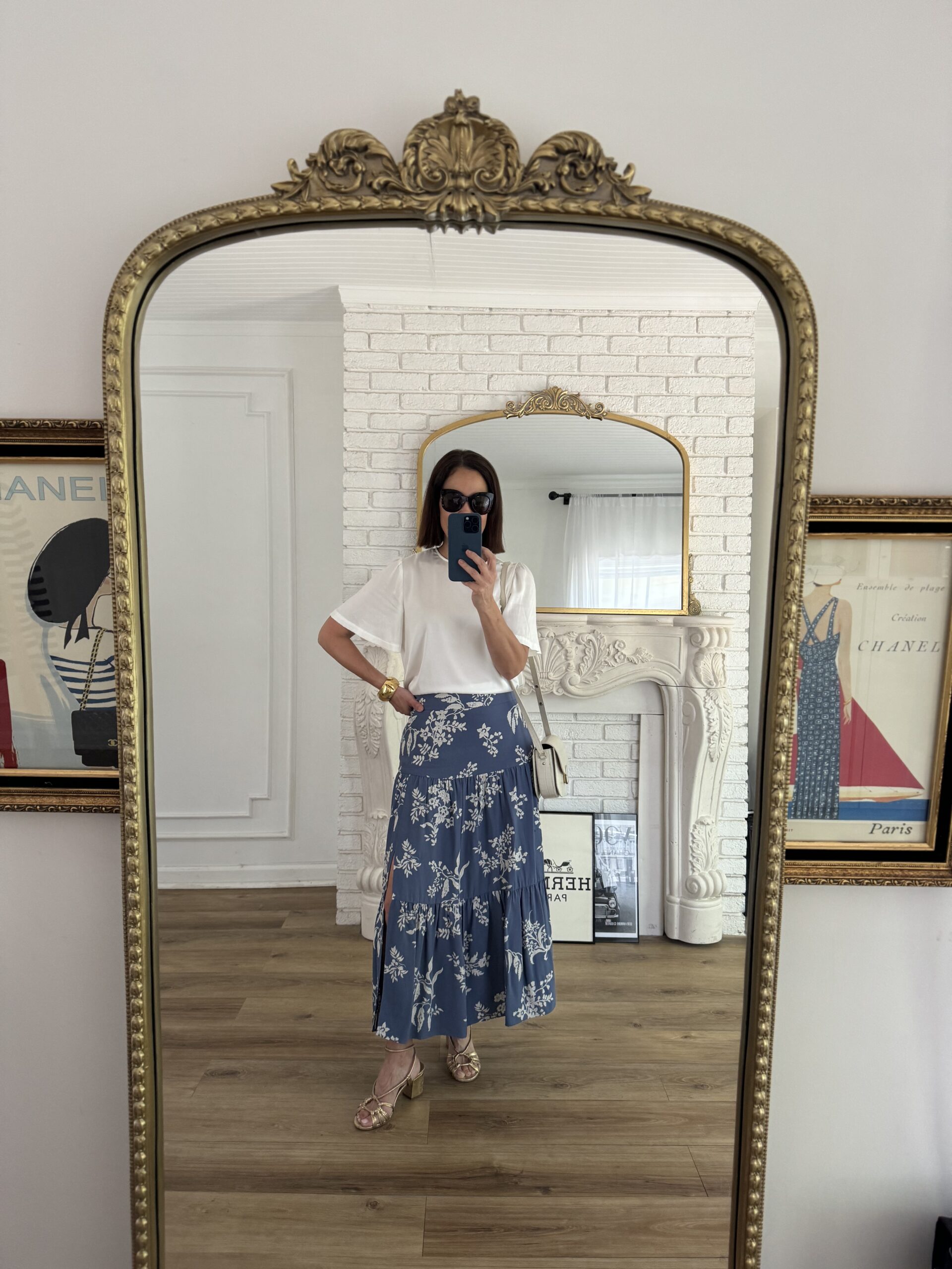 Woman wearing silk skirt with silk top looking into mirror.