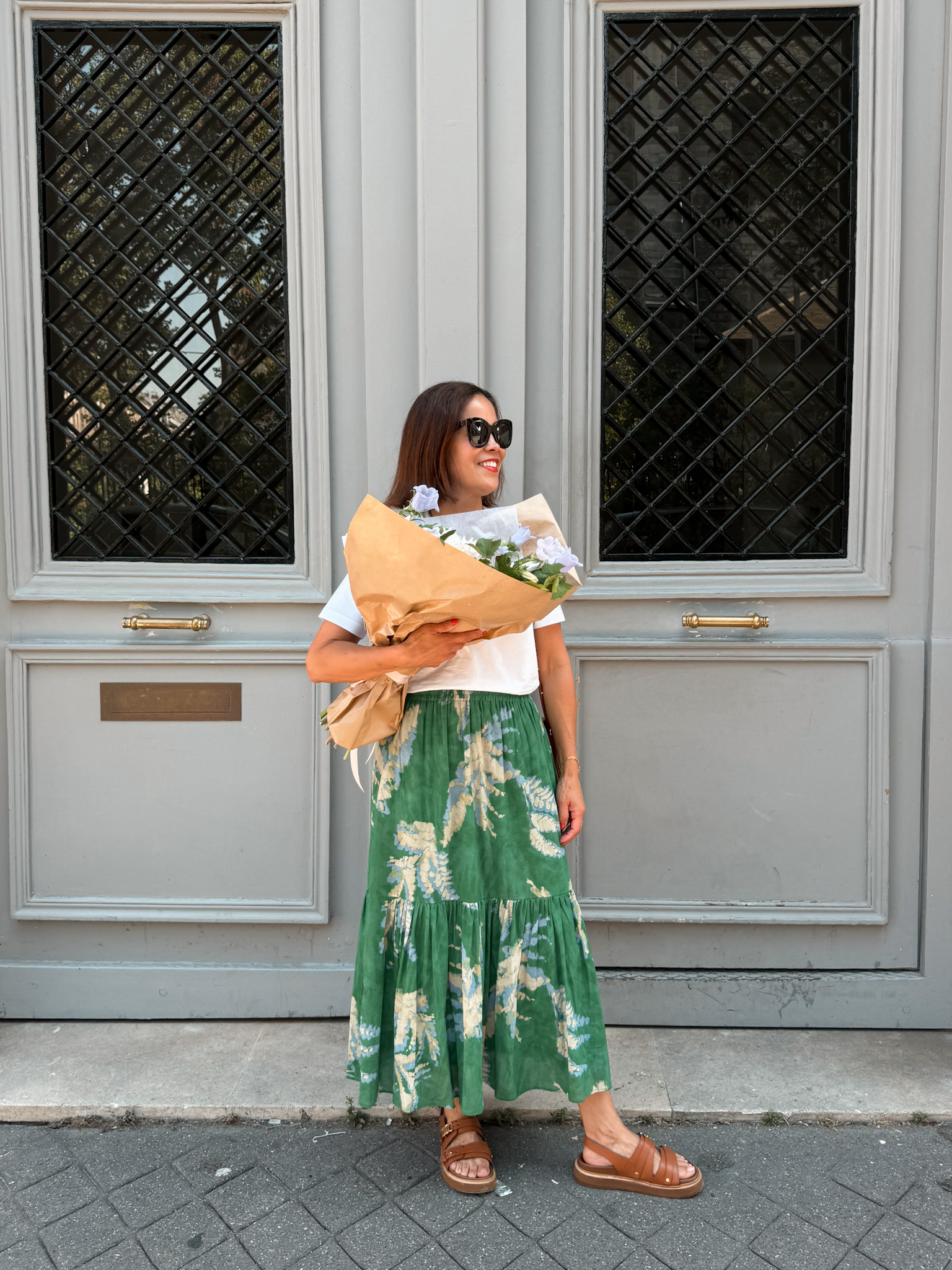 Woman wearing floral skirt with sandals and top.