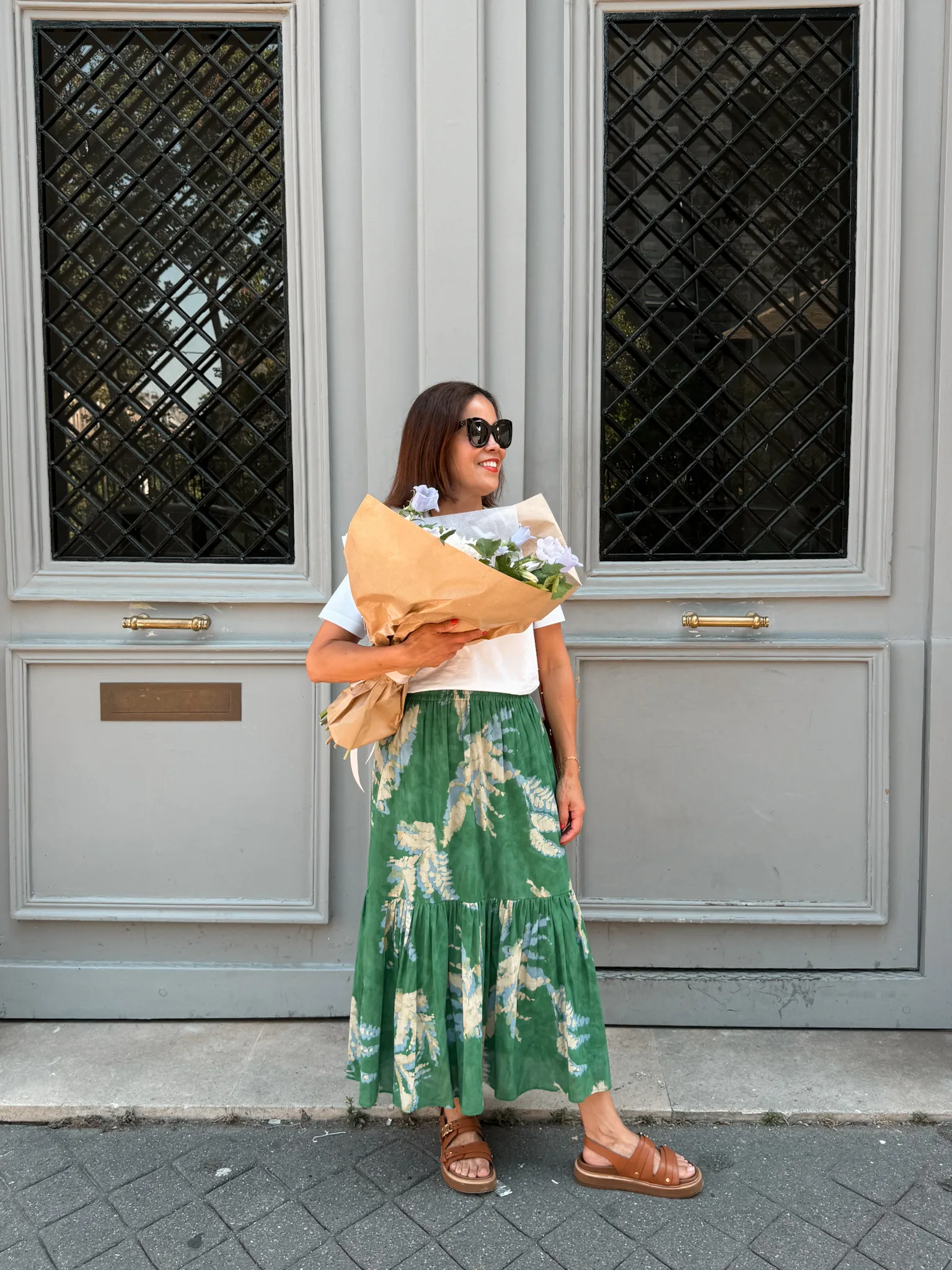 Woman wearing floral skirt with sandals and top.