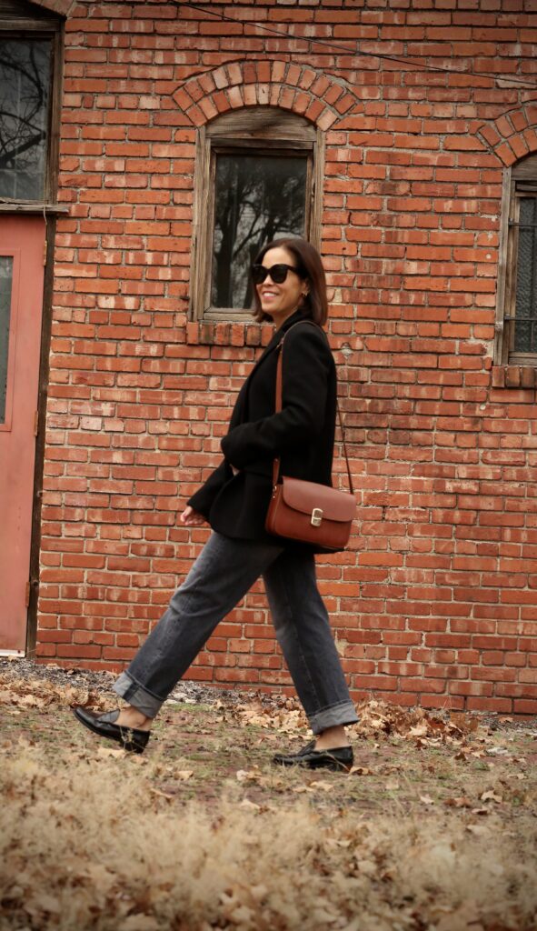 Milo handbag Woman wearing dark denim rolled up with loafers and black blazer.