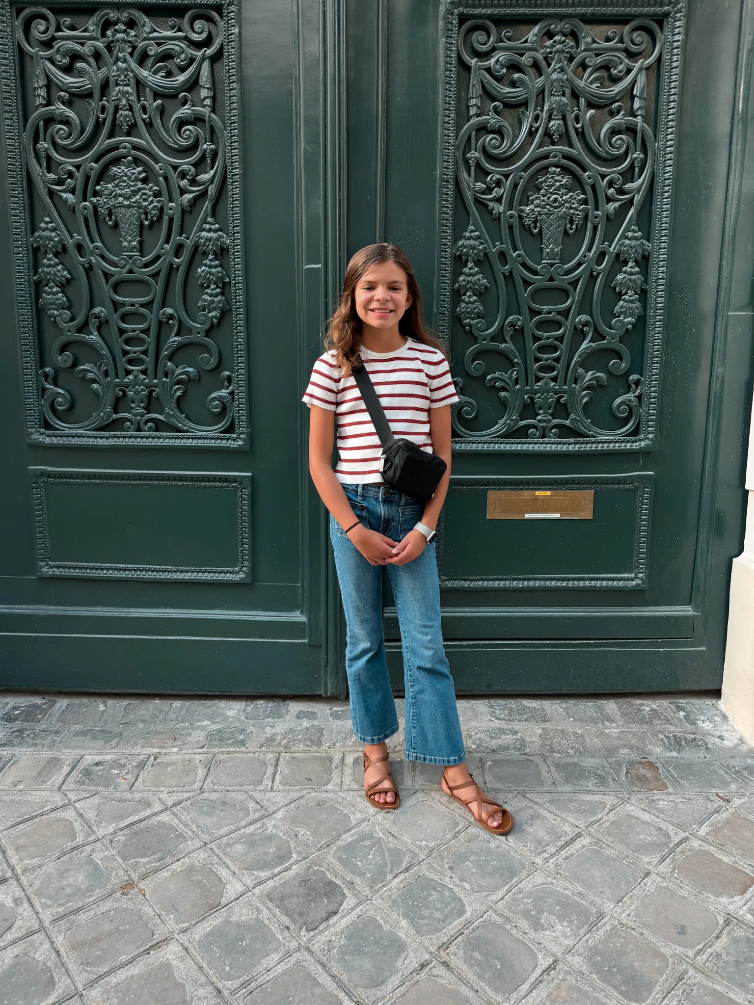 Girl in front of green door in Paris.