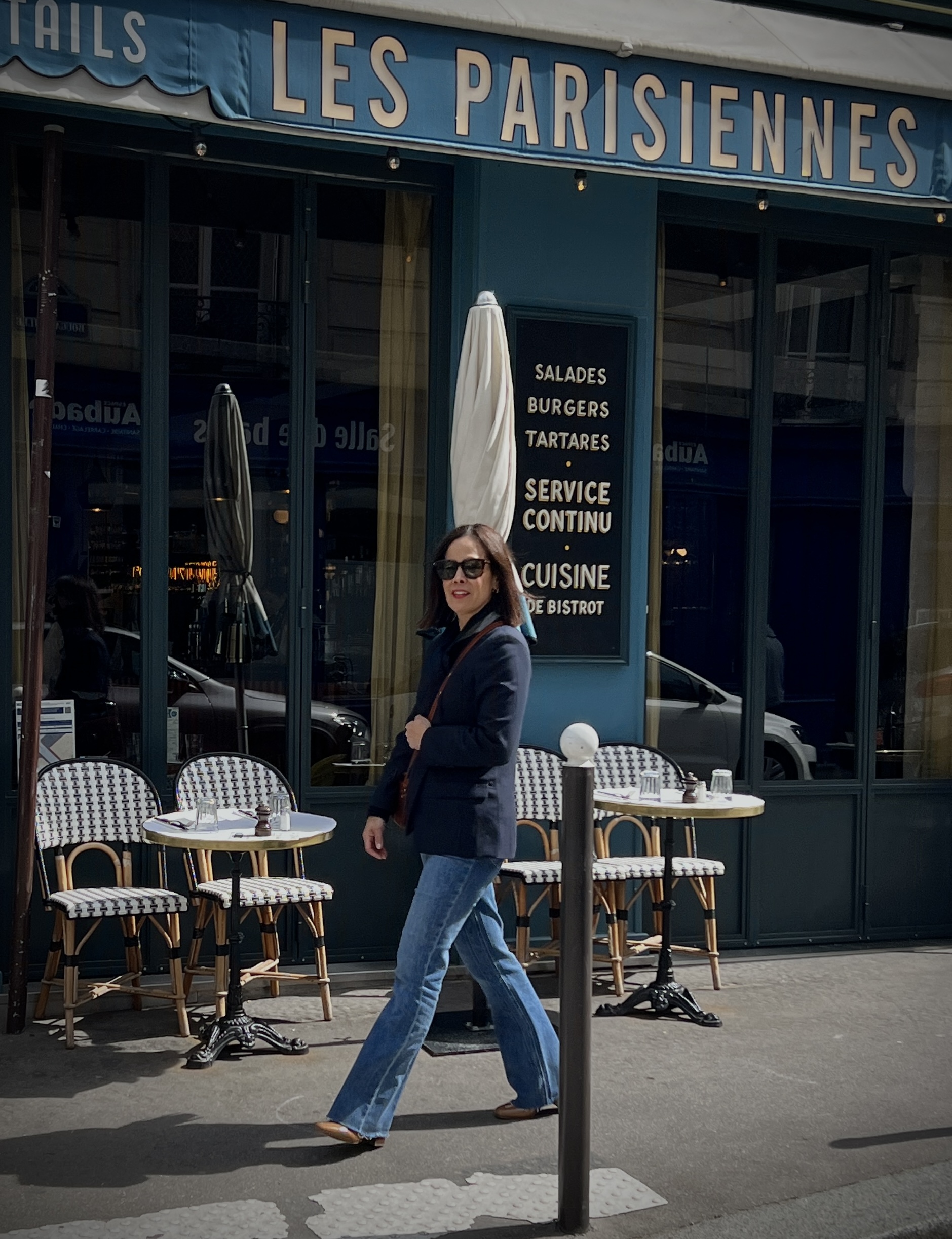 Woman wearing navy blazer with jeans and boots in paris.