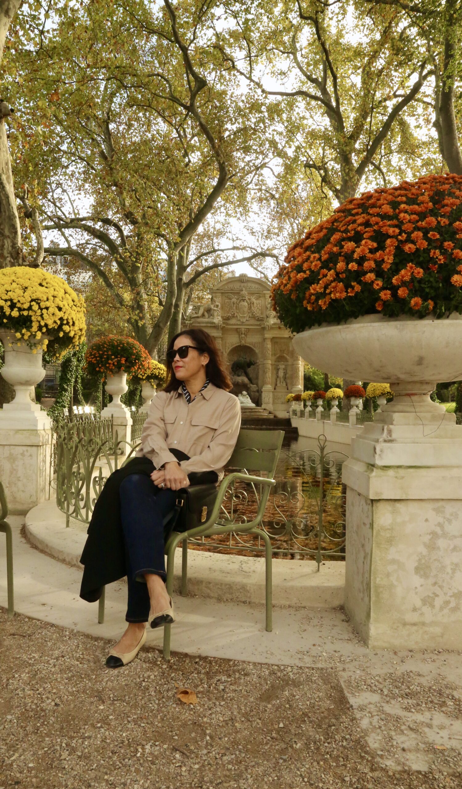 WOMAN SITTING IN LUXEMBOURG GARDENS IN FALL