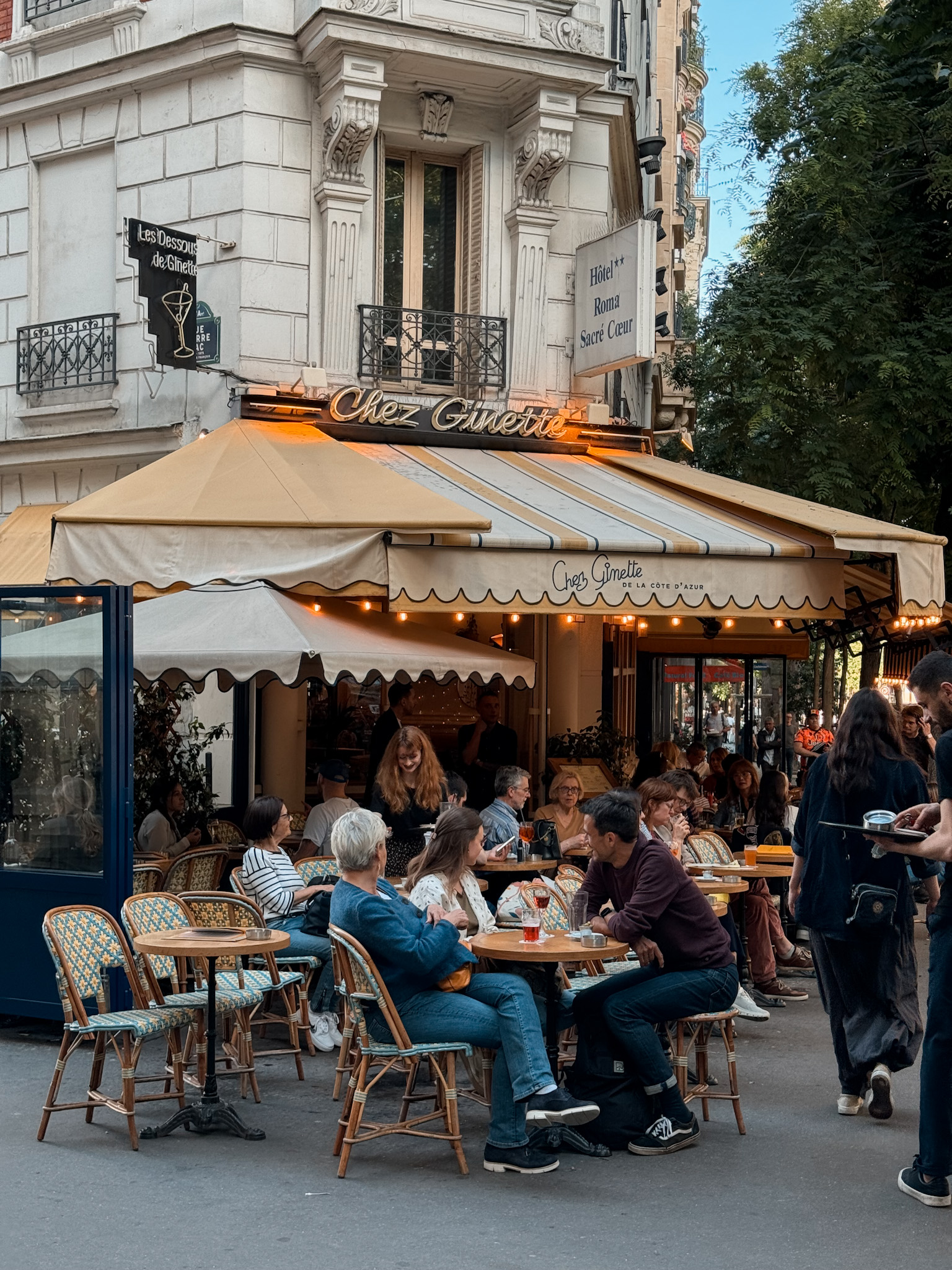 Woman sitting on stoop Paris cafe exterior.