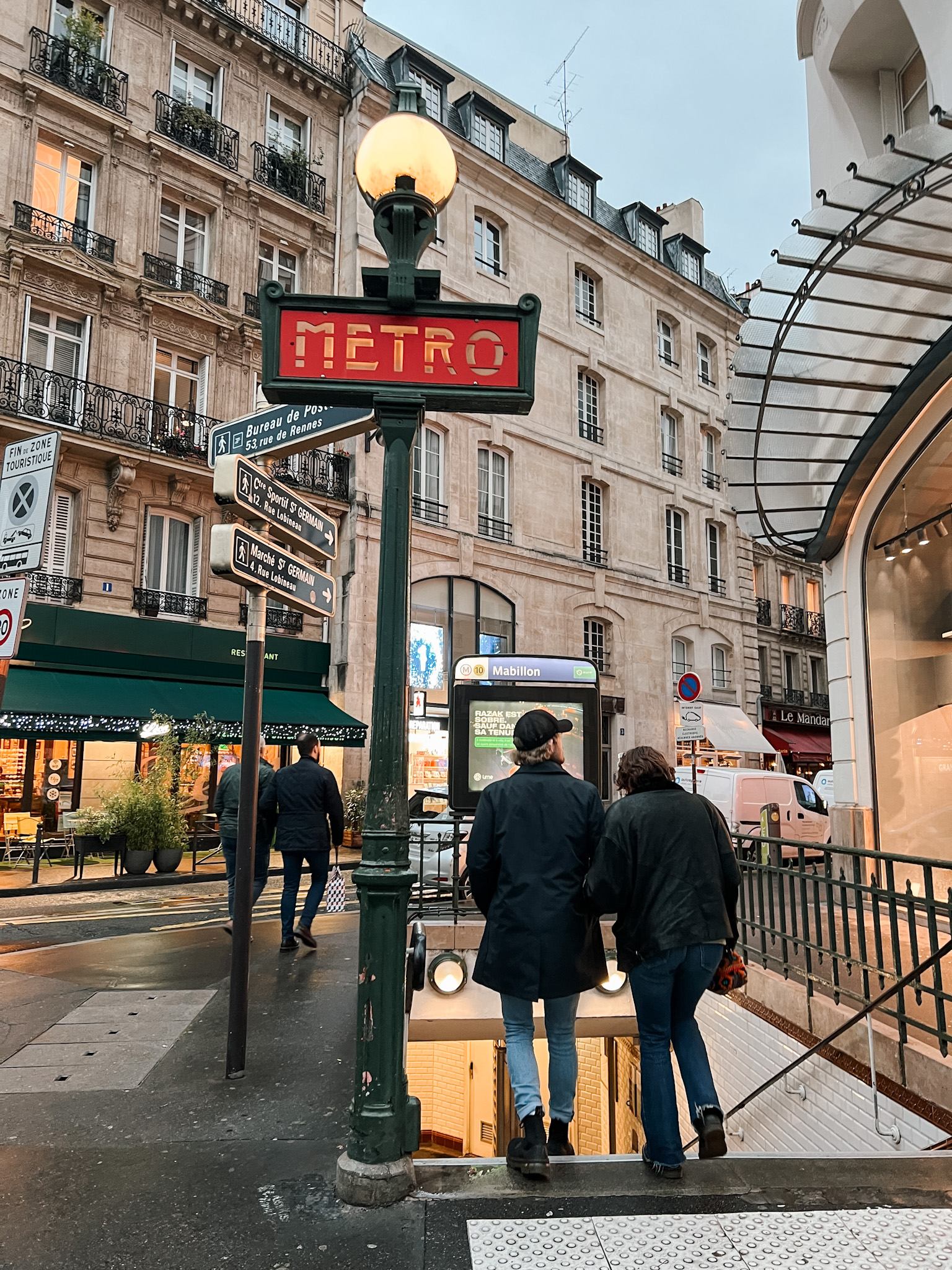 two people walking to a metro stop in Paris.
