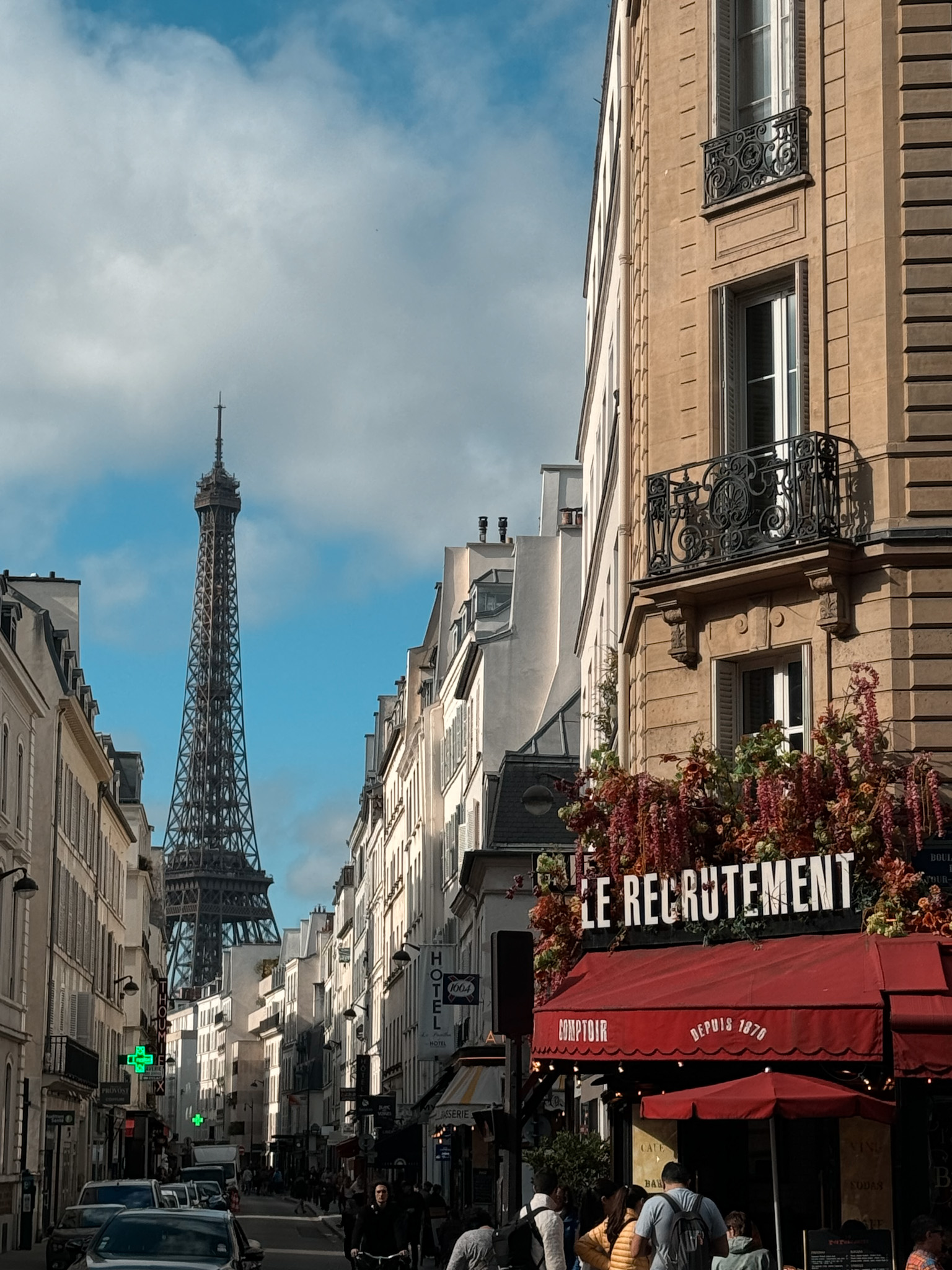 Woman sitting on stoop Eiffel Tower in the background.