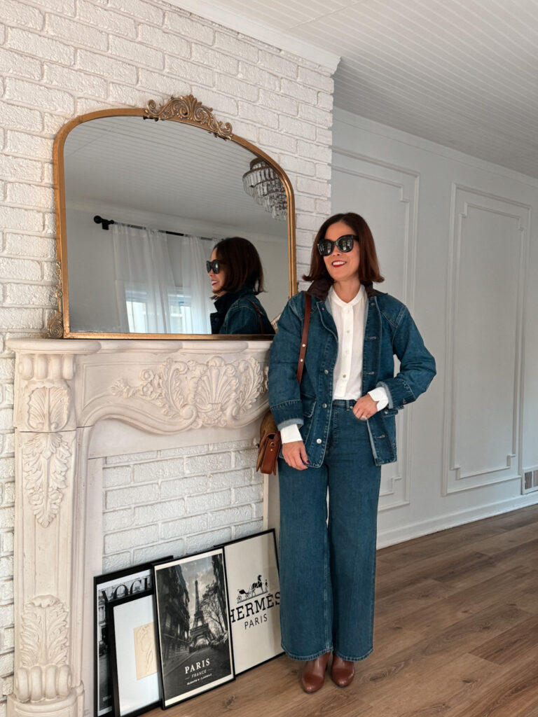 Lady wearing double denim against fireplace.