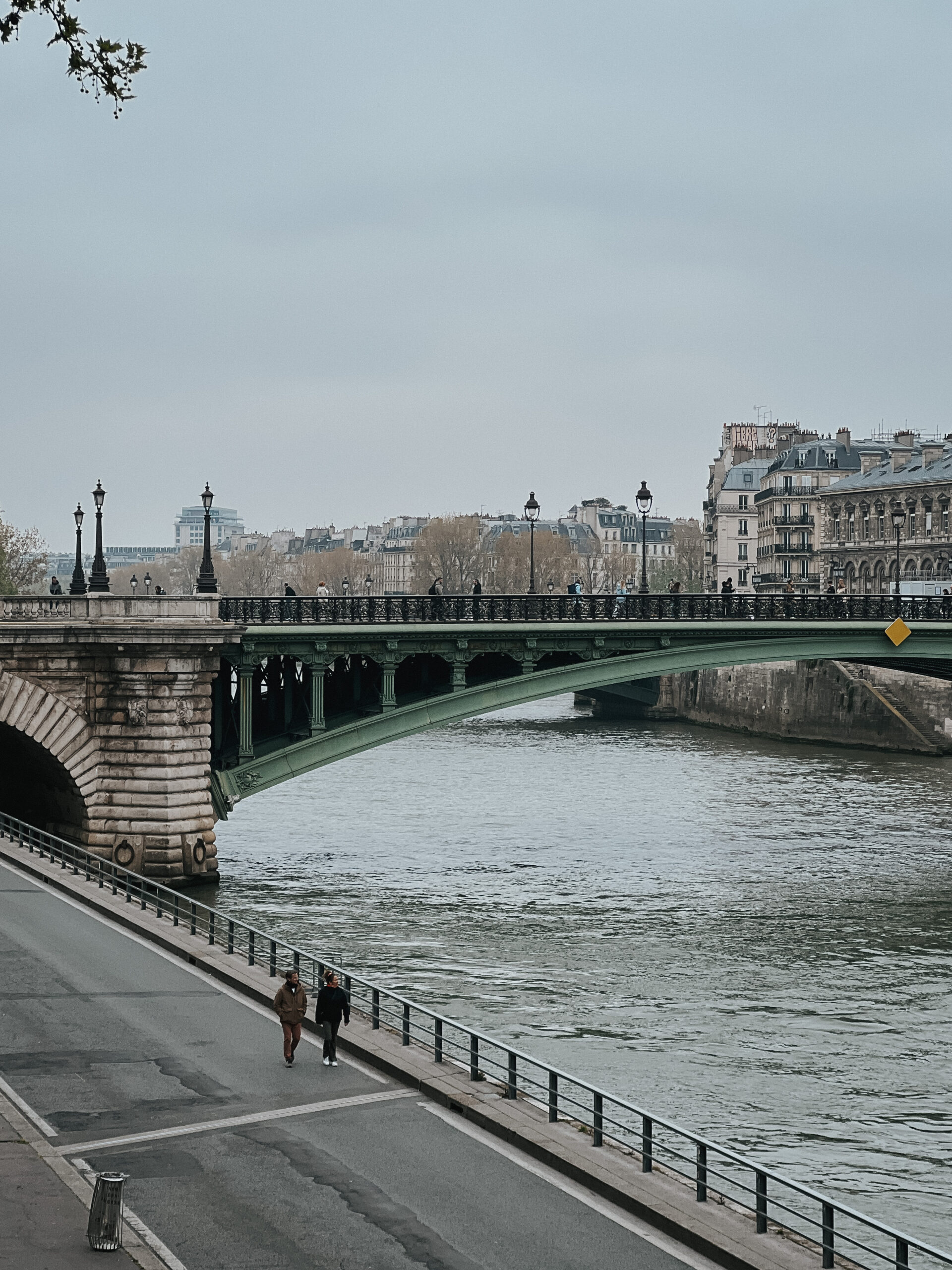 Two people walking outside in Paris in the cold during winter.