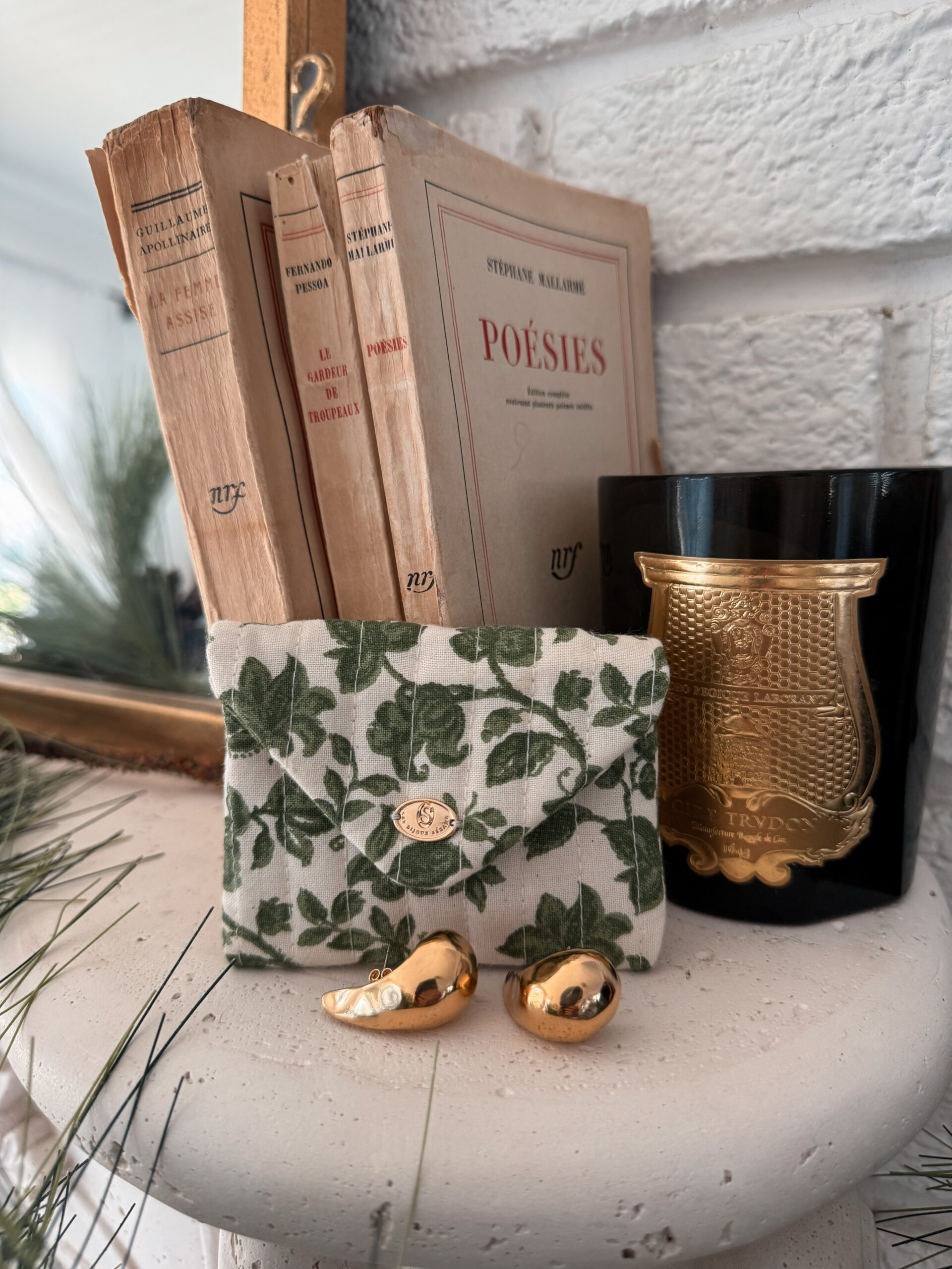 Gold sezane earrings Gold sezane earrings sitting on a mantle.